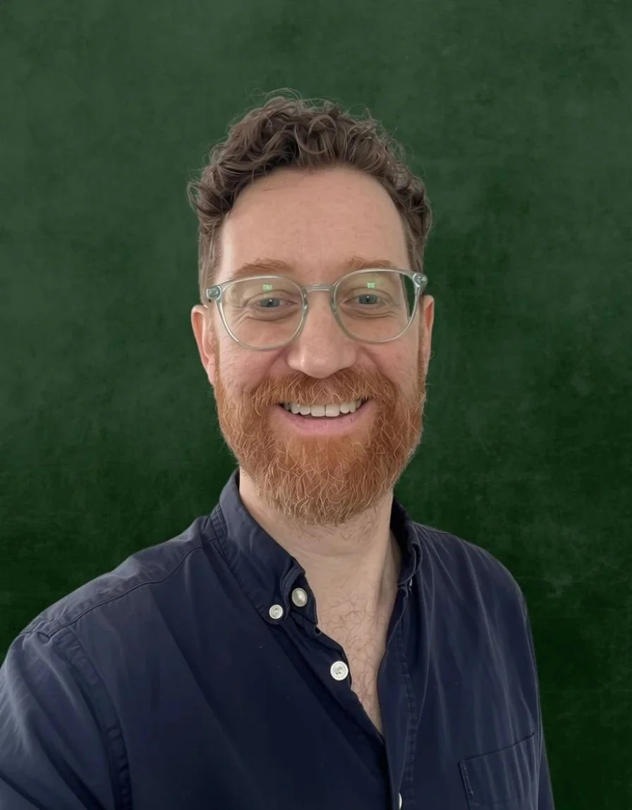 Ted Conway Houston English Tutor with glasses and a beard selfie against a plain green background.