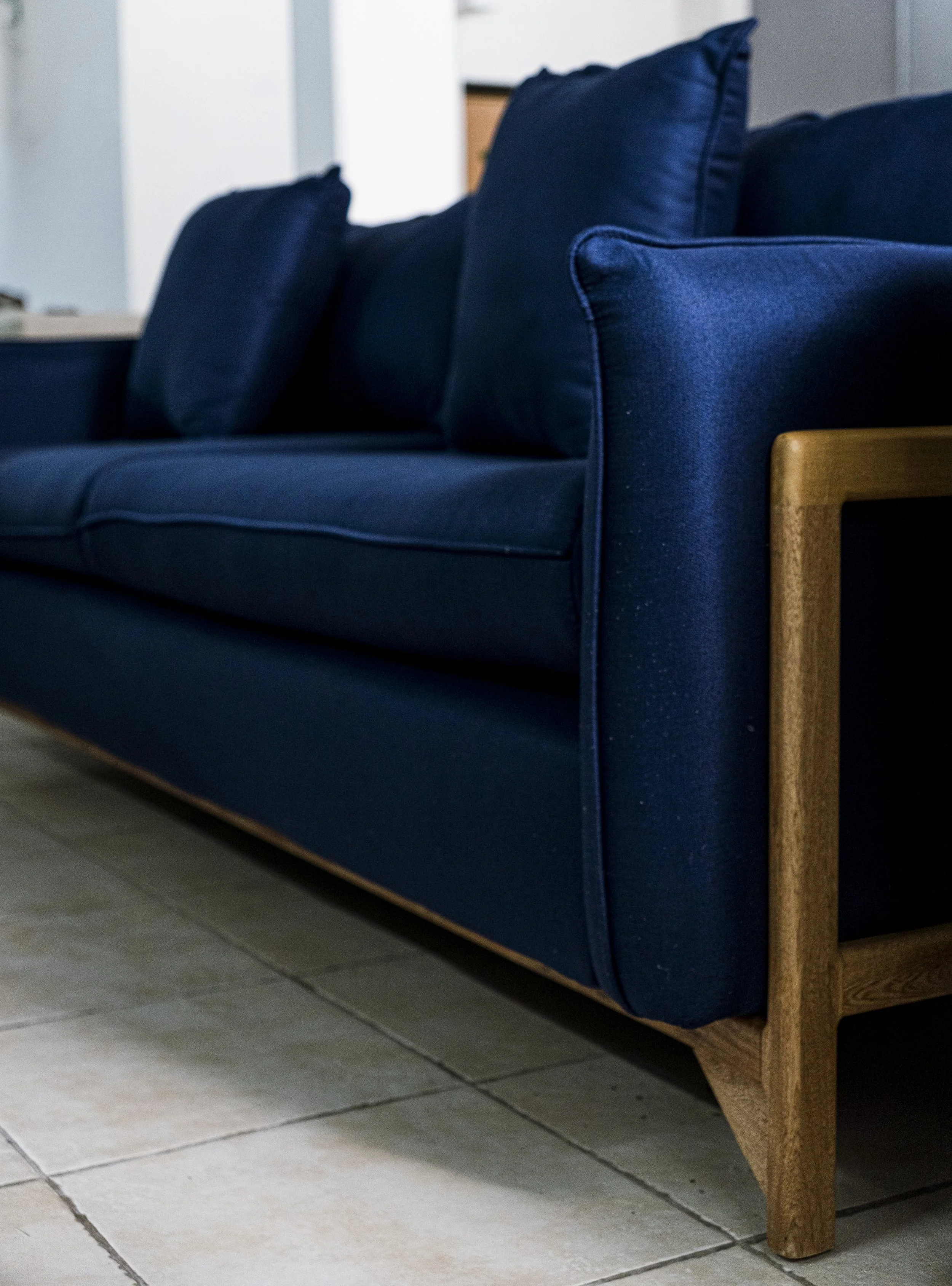 Sofá en tela azúl con base de madera