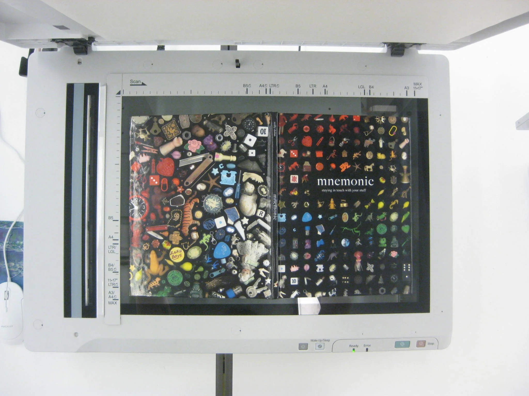 Overhead view of a scanner filled with various small, colorful objects including charms, pins, and mini figurines.