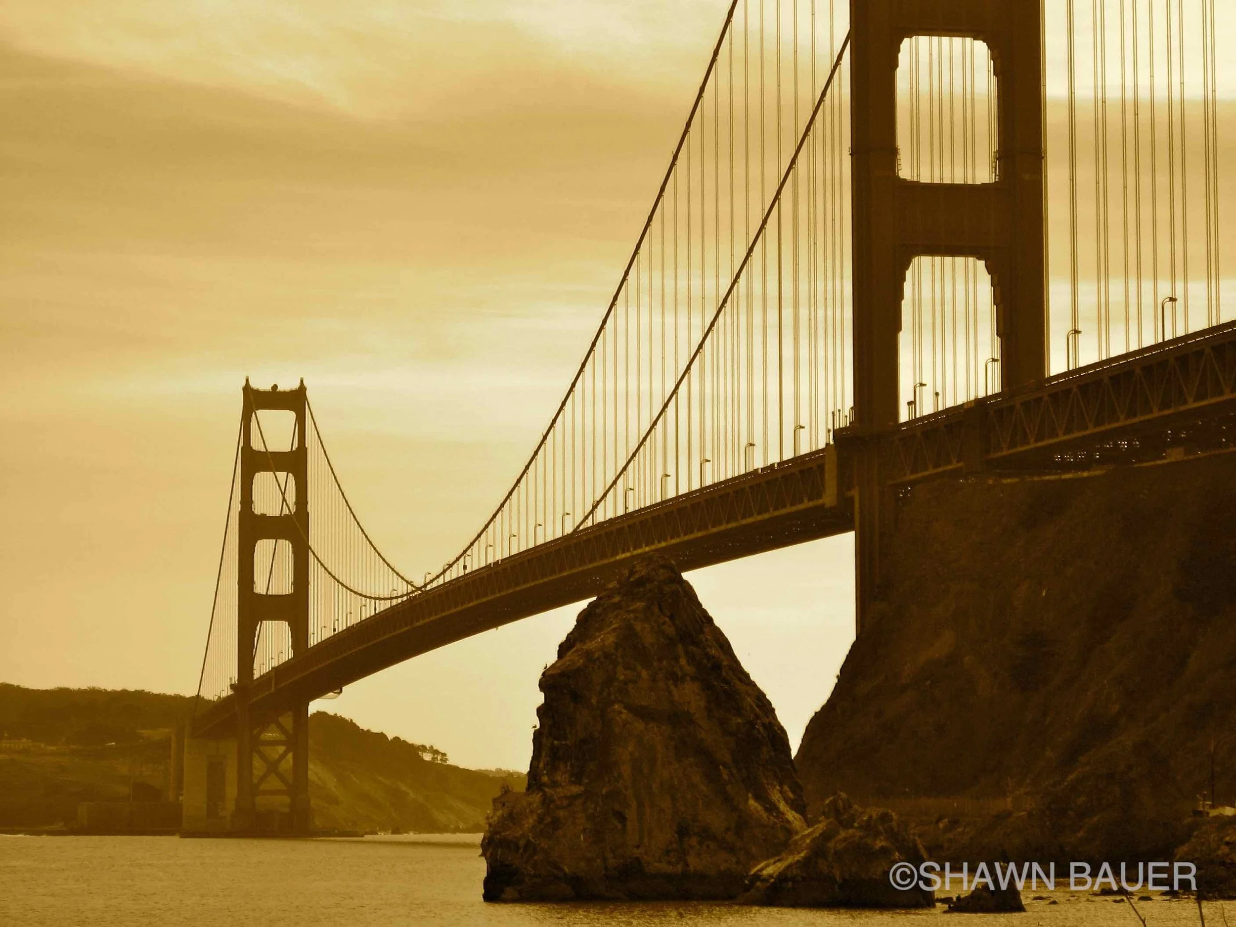 Golden sunset over the San Francisco Bay with the Golden Gate Bridge in the background.
