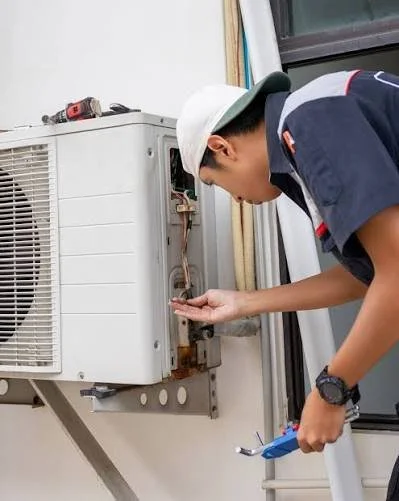Technician repairing an air conditioning unit.