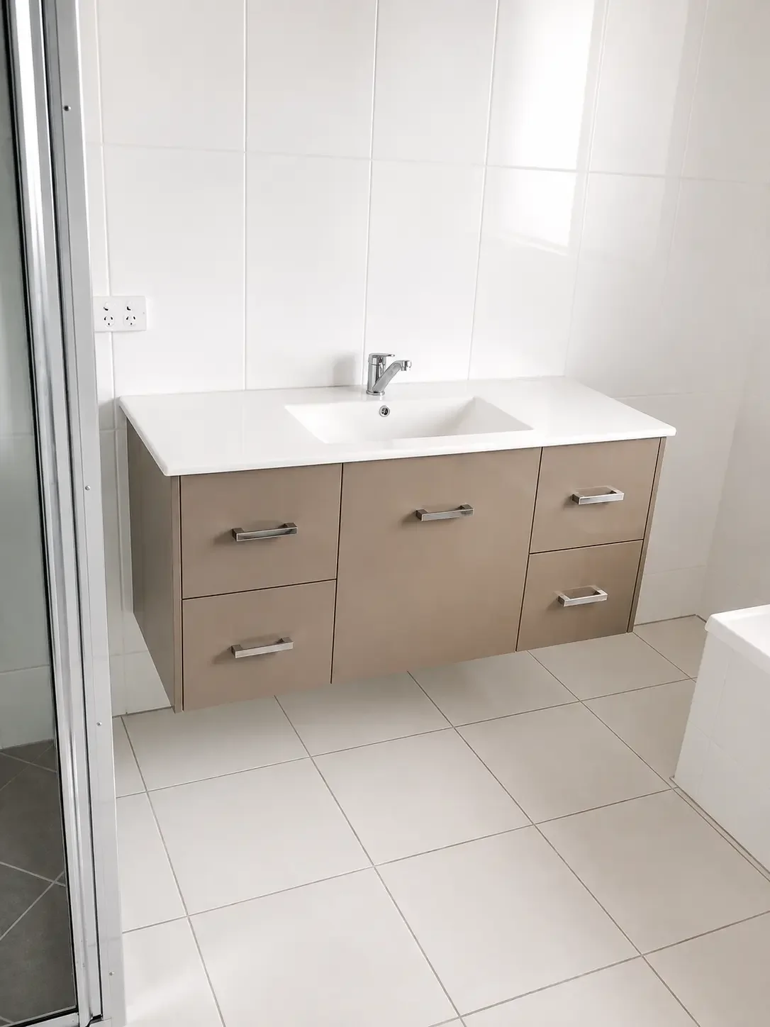 Light timber-look bathroom vanity with white benchtop and inset basin.
