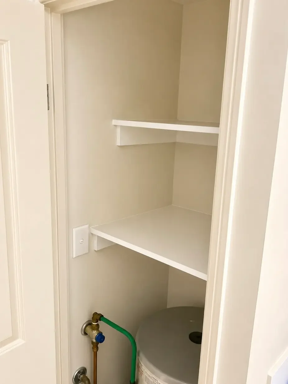 Built-in storage cupboard with internal shelving and space for the hot-water system.
