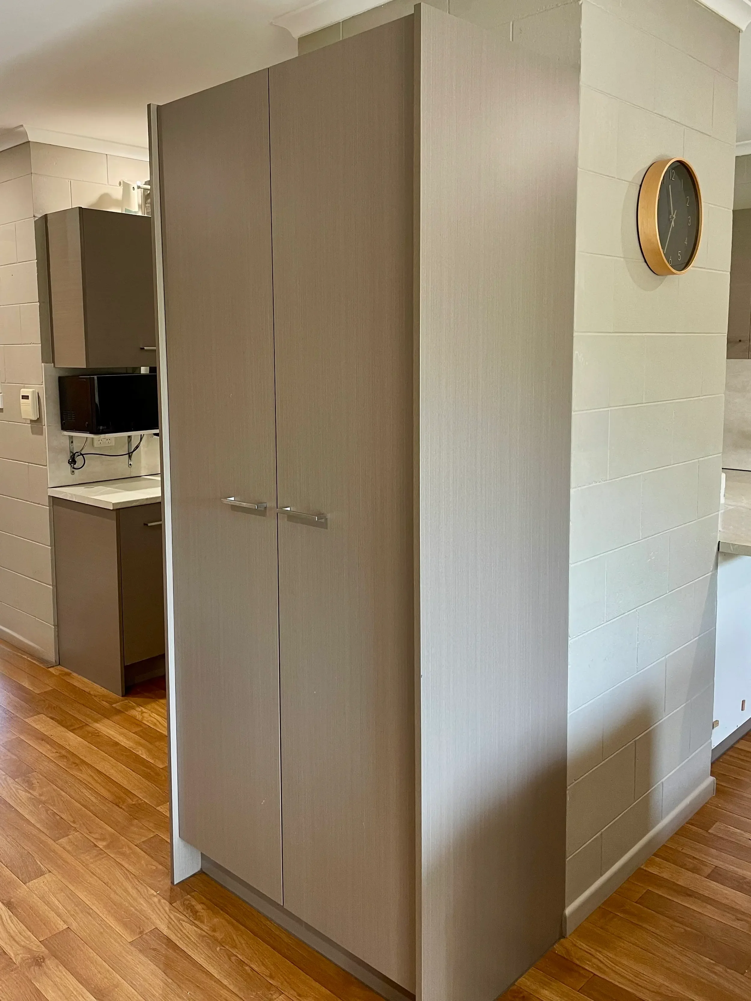 Tall beige cabinetry providing built-in storage beside the kitchen.
