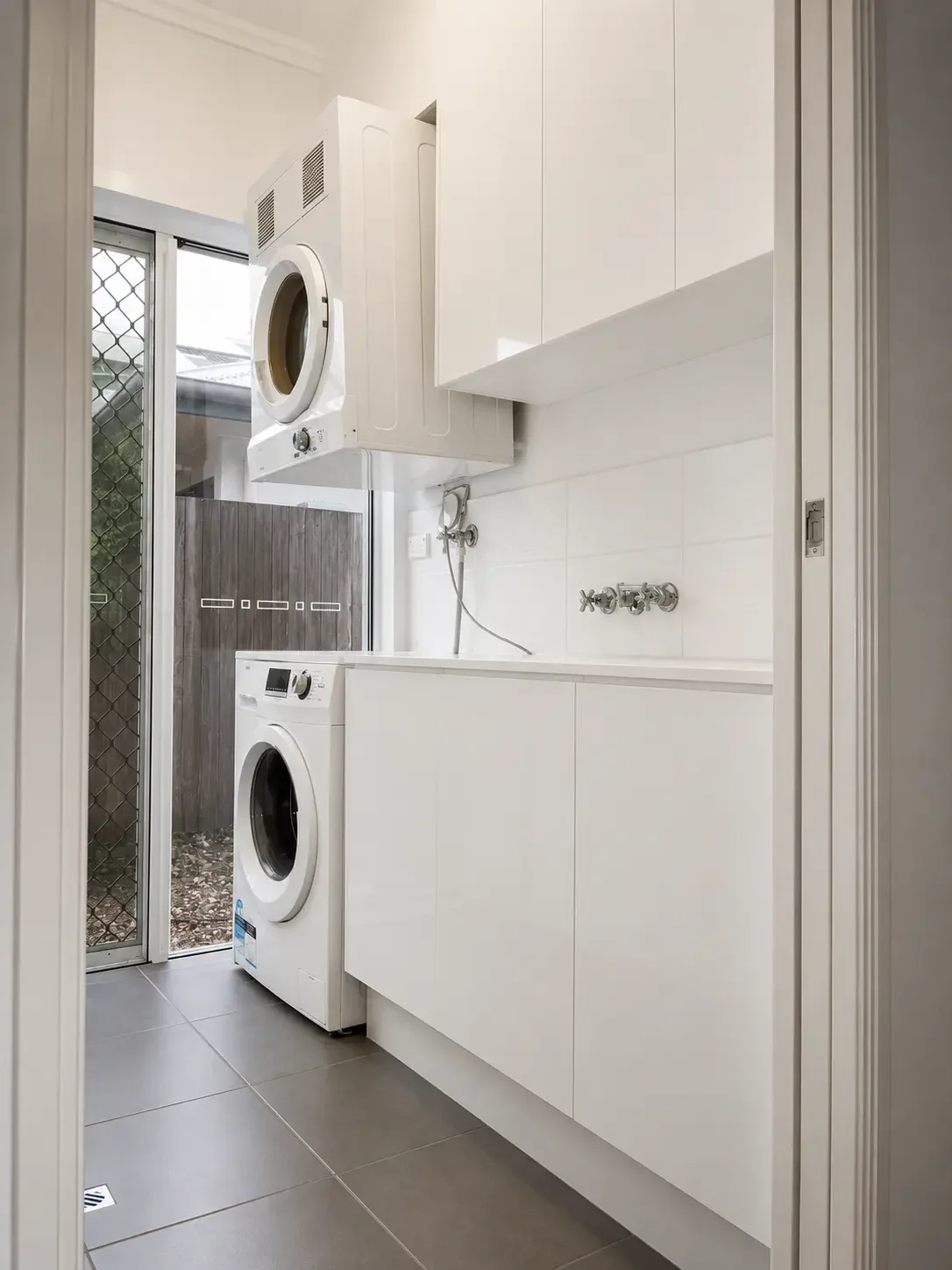 Custom laundry cabinetry with sink and overhead storage