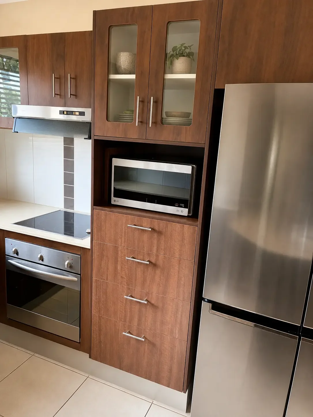 Timber-look kitchen cabinetry with built-in microwave and stainless steel appliances.
