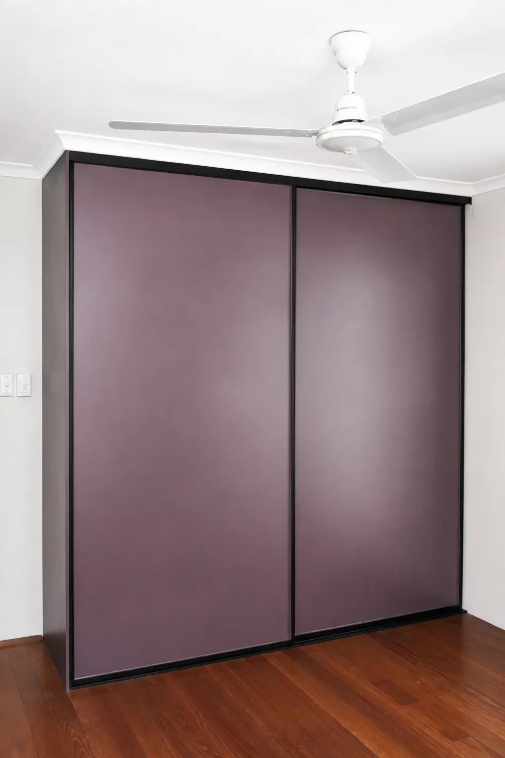 Sliding-door wardrobe with purple panels and black framing.
