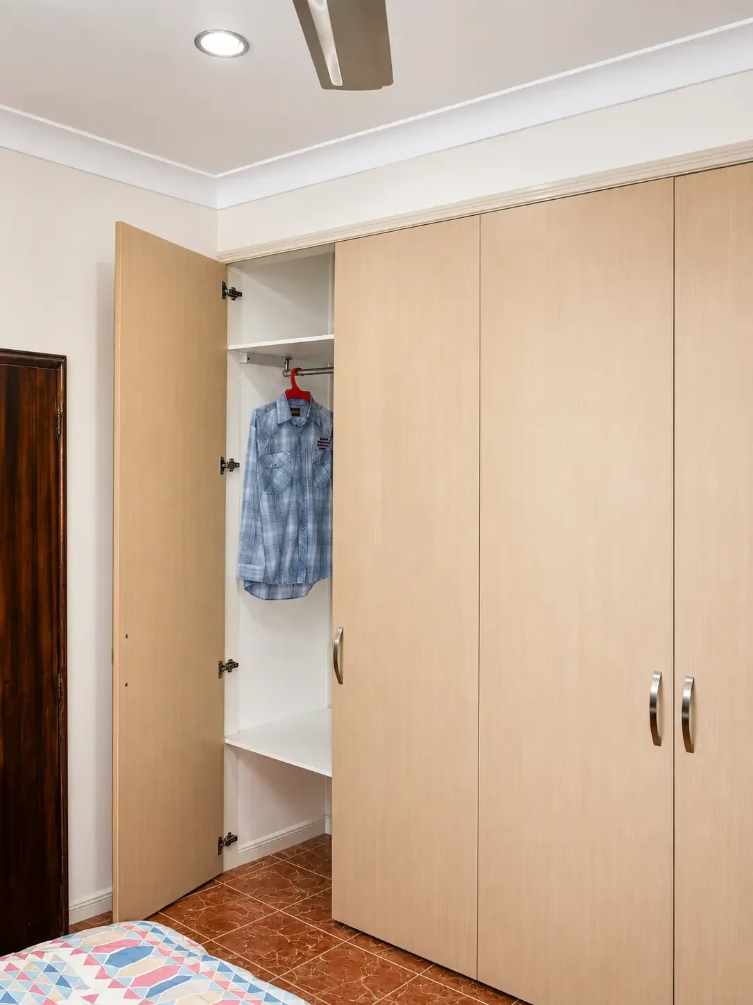 Built-in wardrobe with light timber-look doors and internal hanging space.
