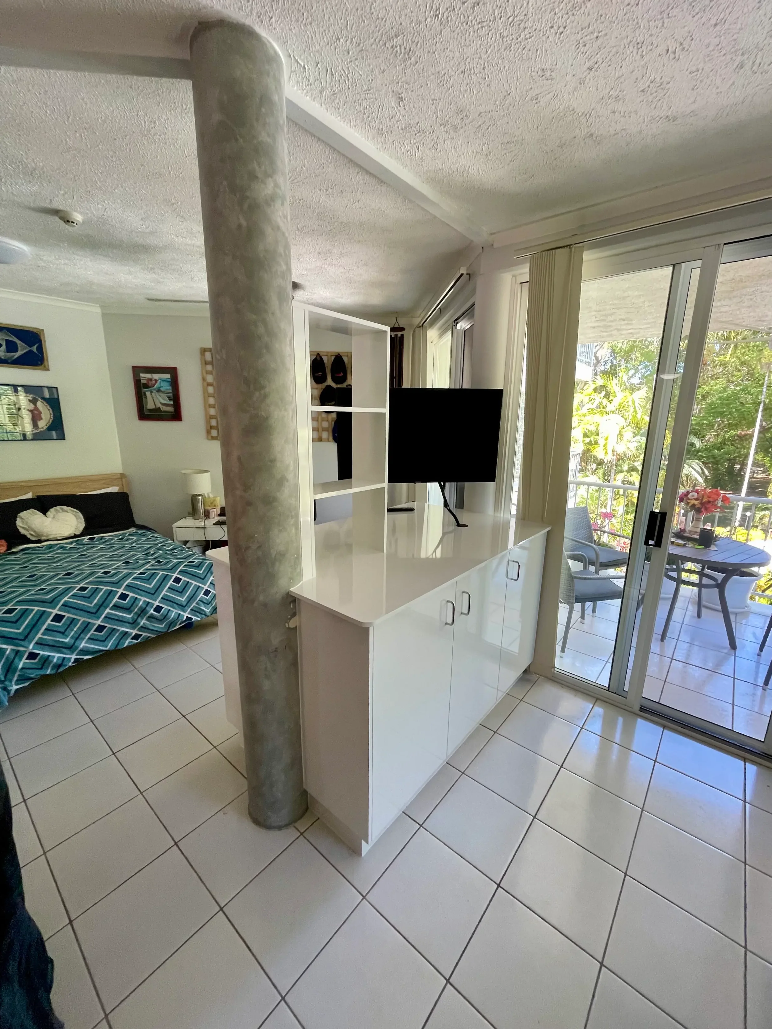 White built-in entertainment cabinetry with television space and adjoining storage.
