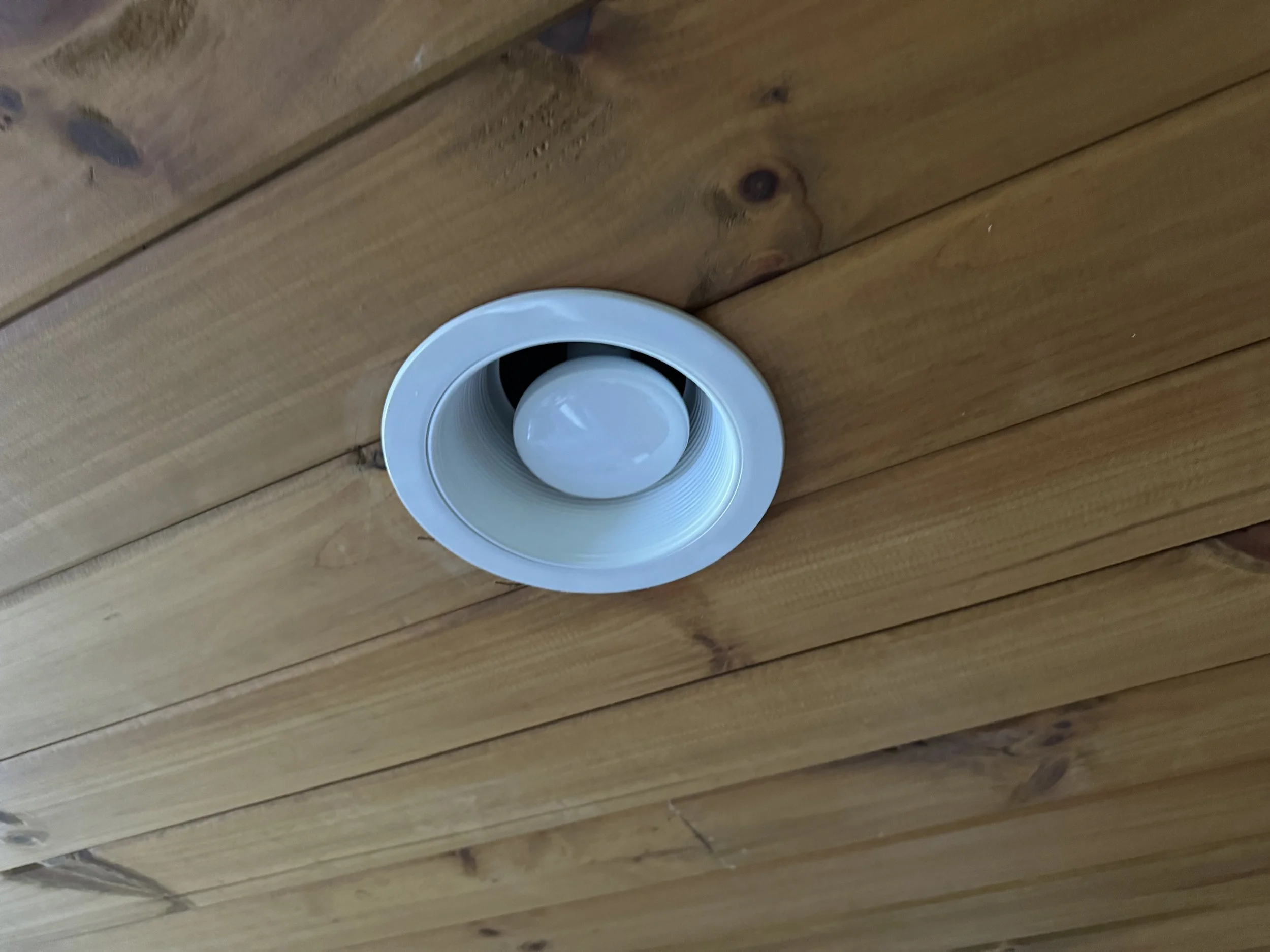 White cup placed upside down on a wooden surface.
