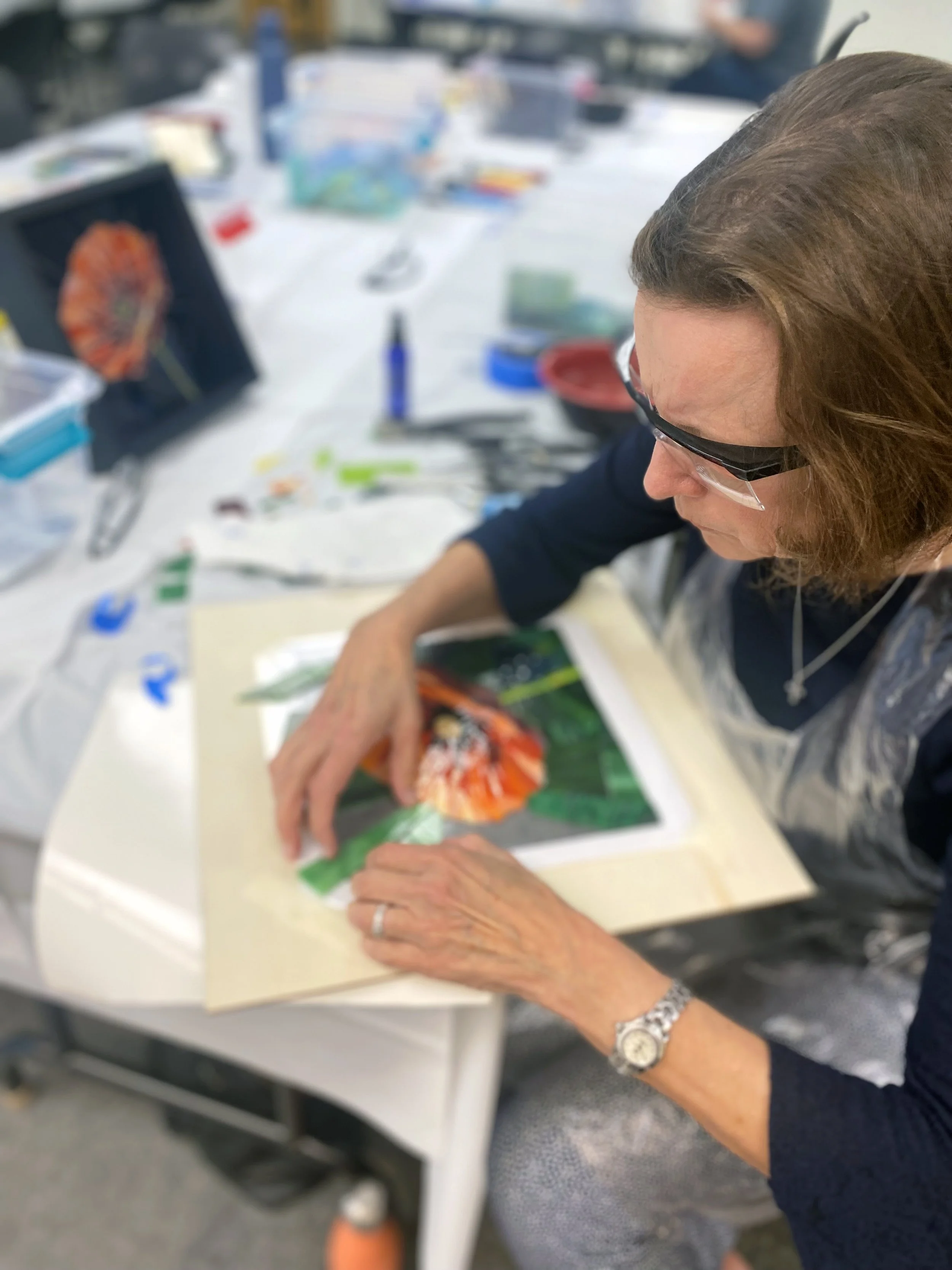 Student creating a mosaic flower portrait during a class