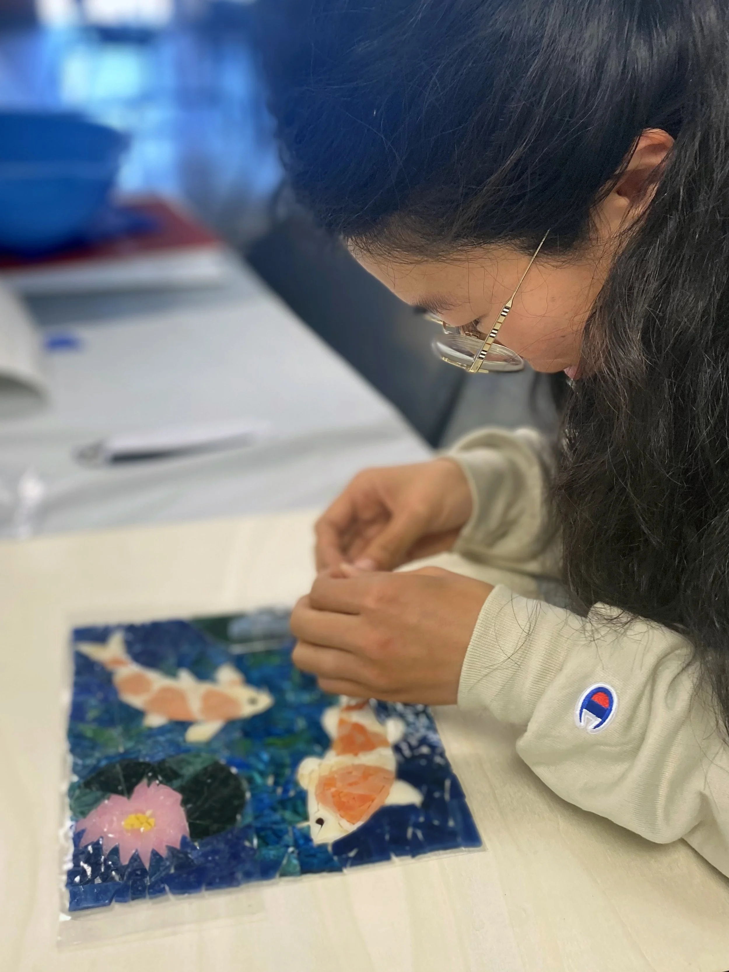 Student creating a mosaic of fish during a class