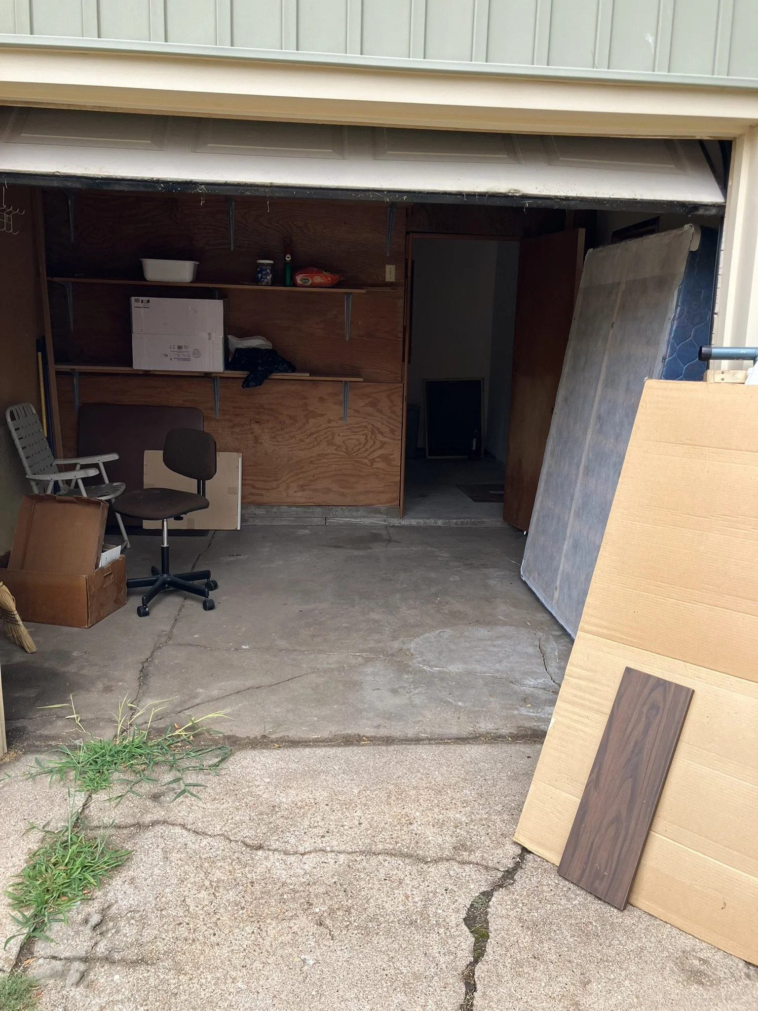 Garage filled with unwanted furniture, boxes, mattress, and household items before a complete junk removal and garage cleanout by Junk Boys in Wichita, Kansas.