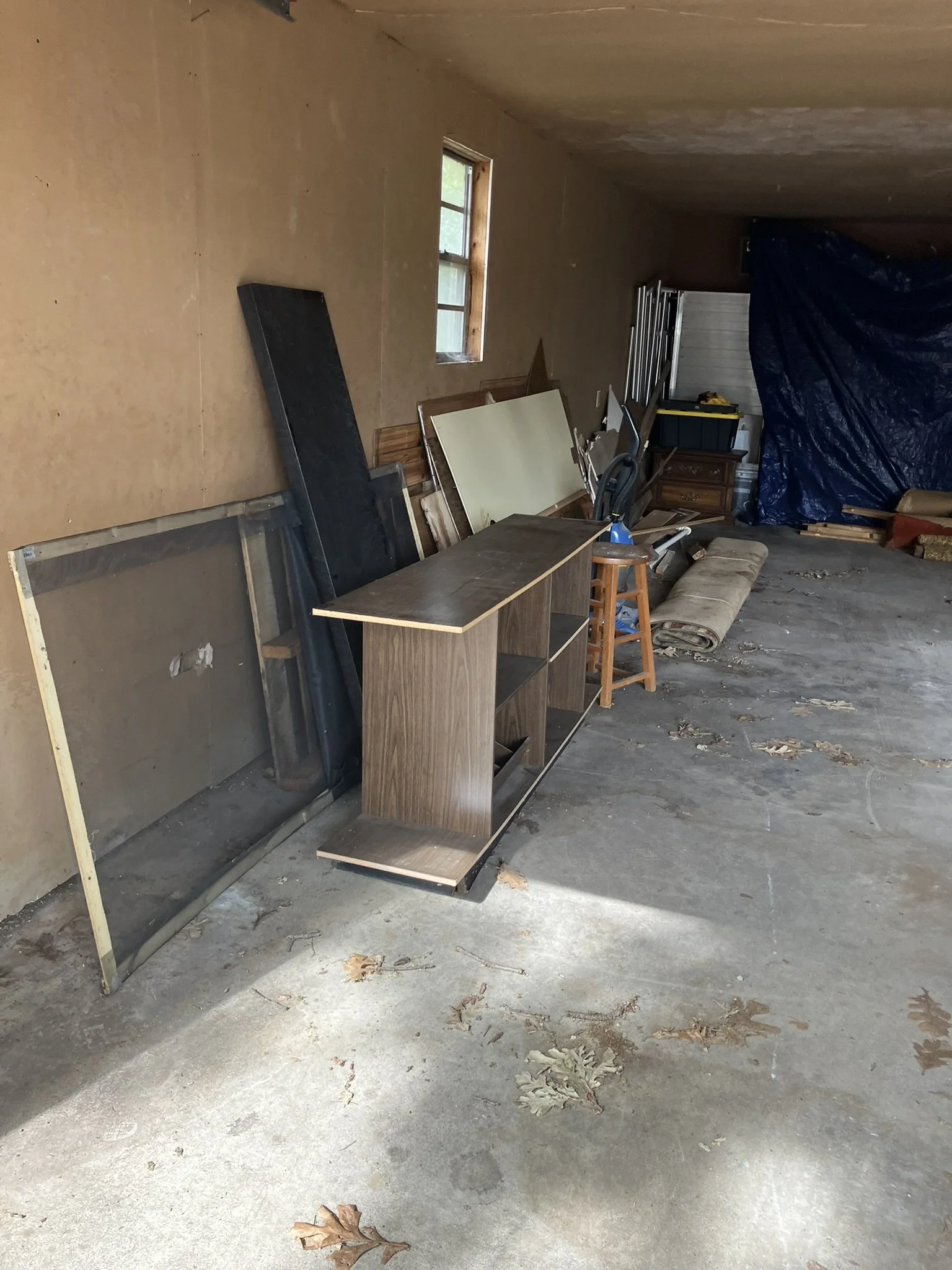 Garage packed with unwanted furniture, appliances, and household items before a complete garage cleanout by Junk Boys.