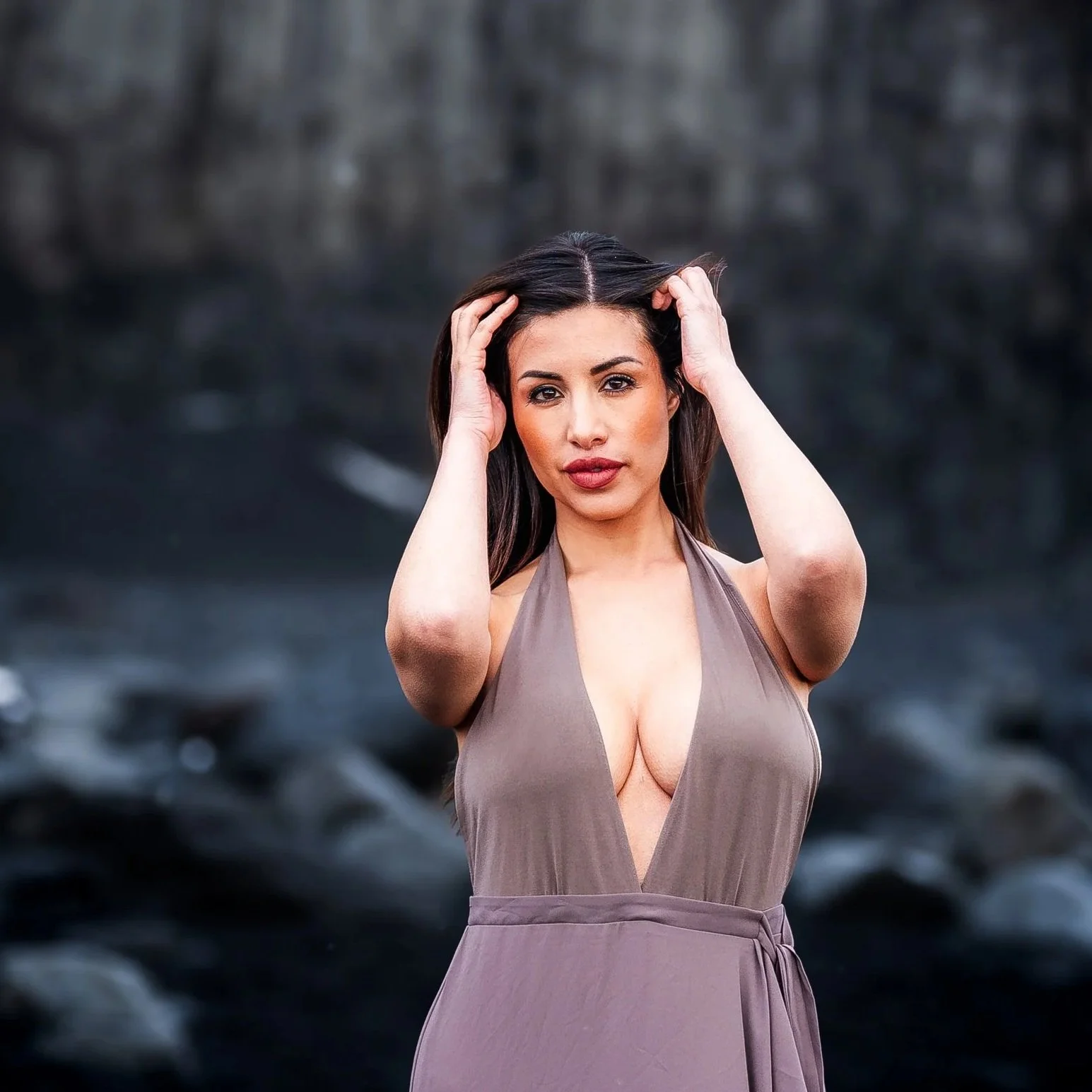 Michelle Benitez, Univision news anchor, posing on a black sand beach in Iceland with a blurred natural background.