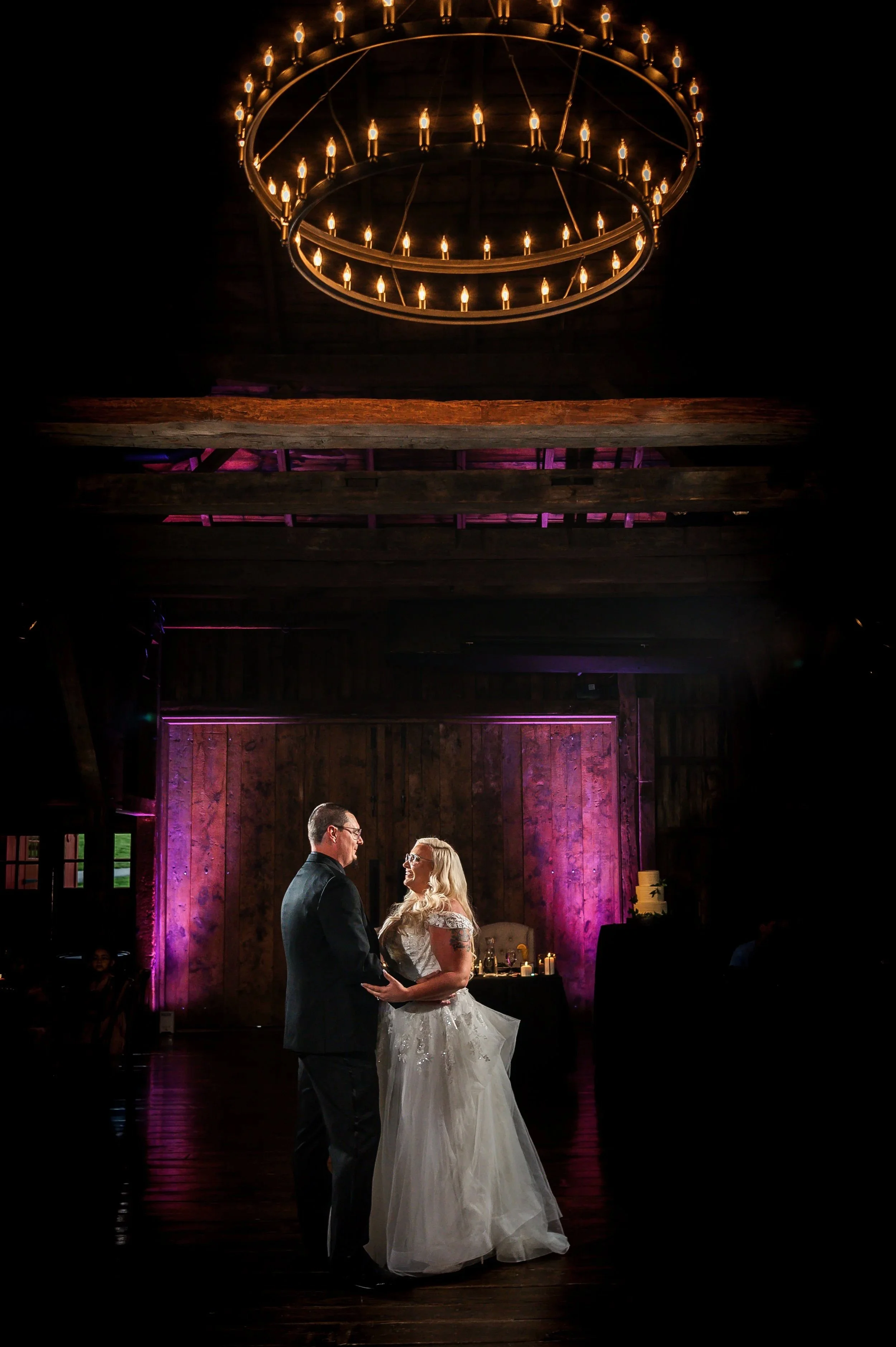 Bride and groom dancing at their wedding reception at The Farm at Eagles Ridge, Lancaster PA, barn with wood walls and a large chandelier overhead.