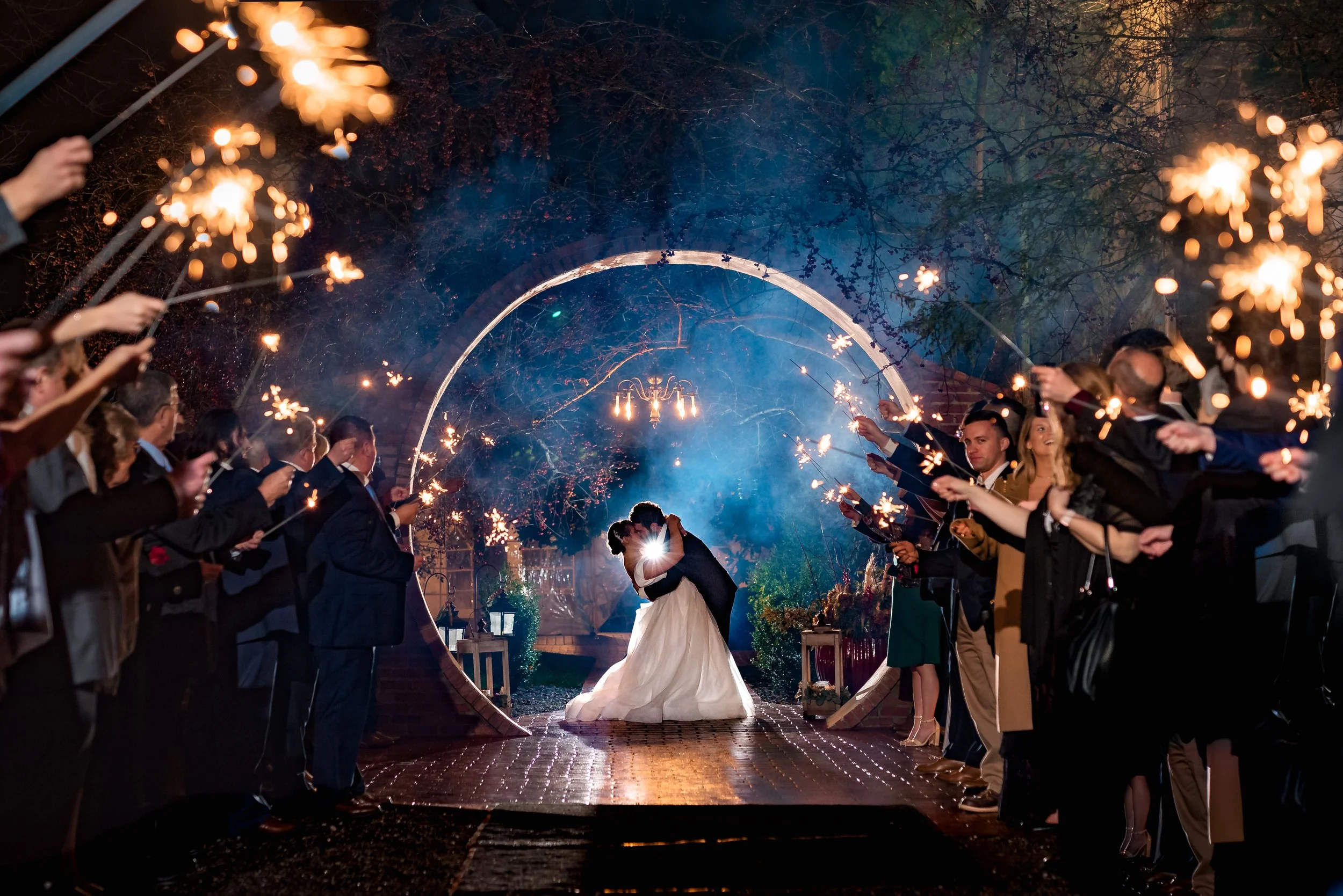 Newlyweds embracing and kissing beneath a round stone moongate archway at Stone Mill Inn wedding venue in Hallam, Pennsylvania
