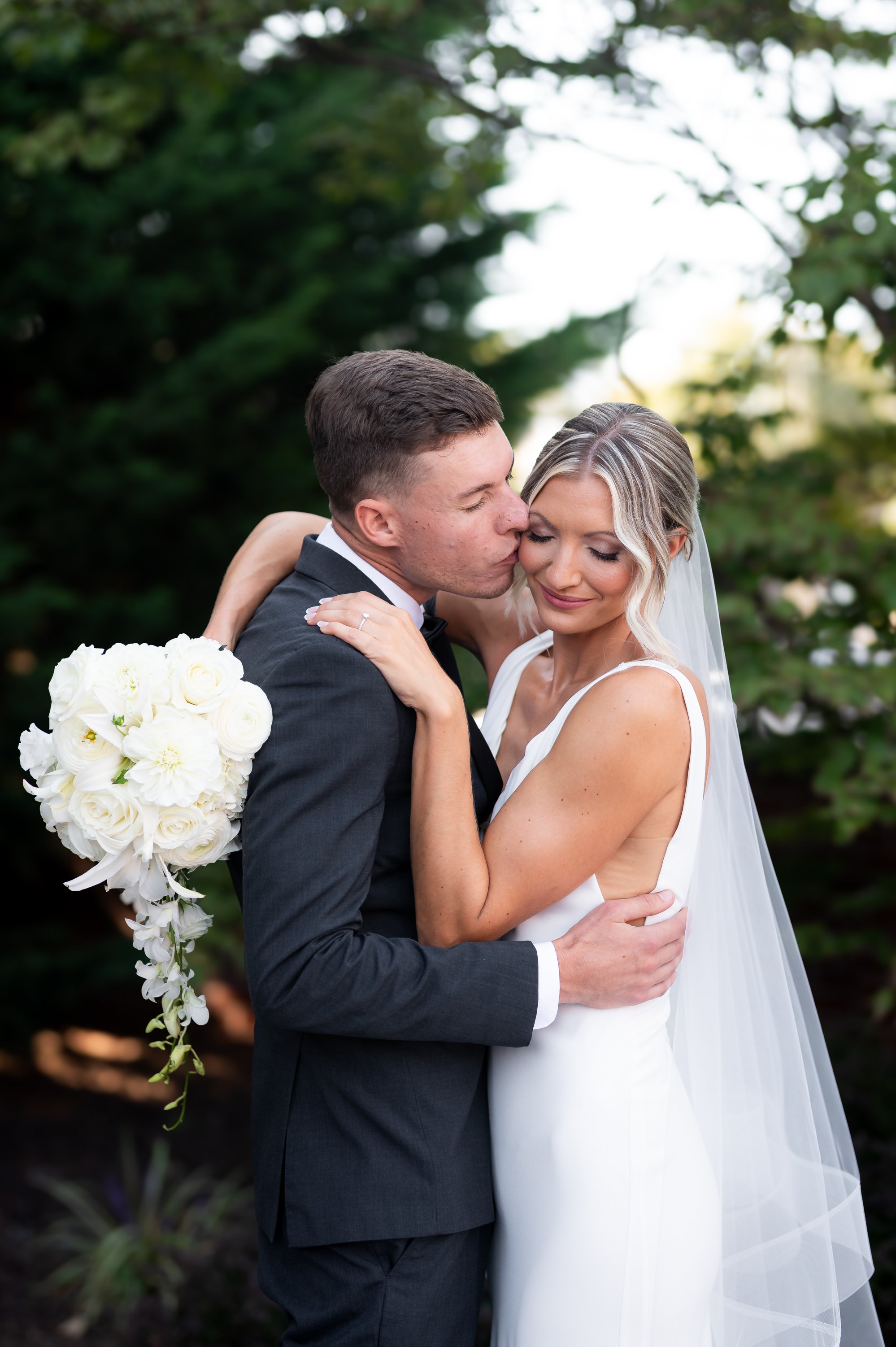 Groom kissing bride's cheek at Cork Factory Hotel in Lancaster, PA