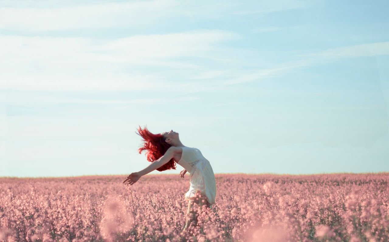 joyful woman in a field of pink flowers