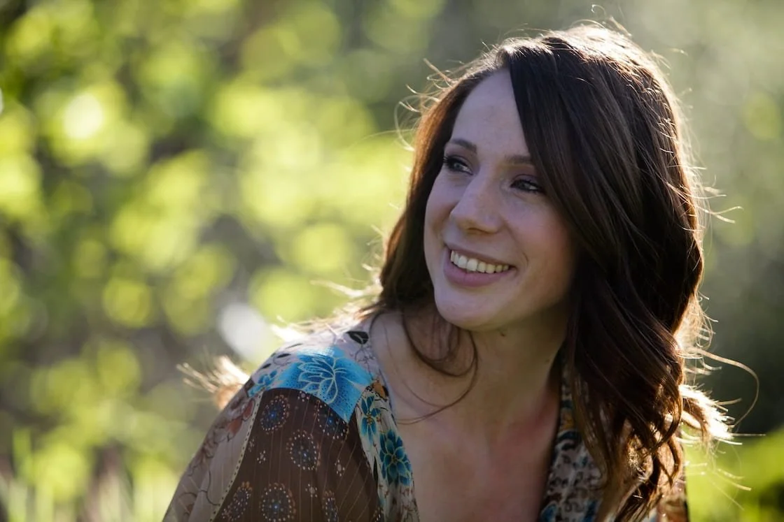 picture of the therapist, in nature, smiling over her shoulder