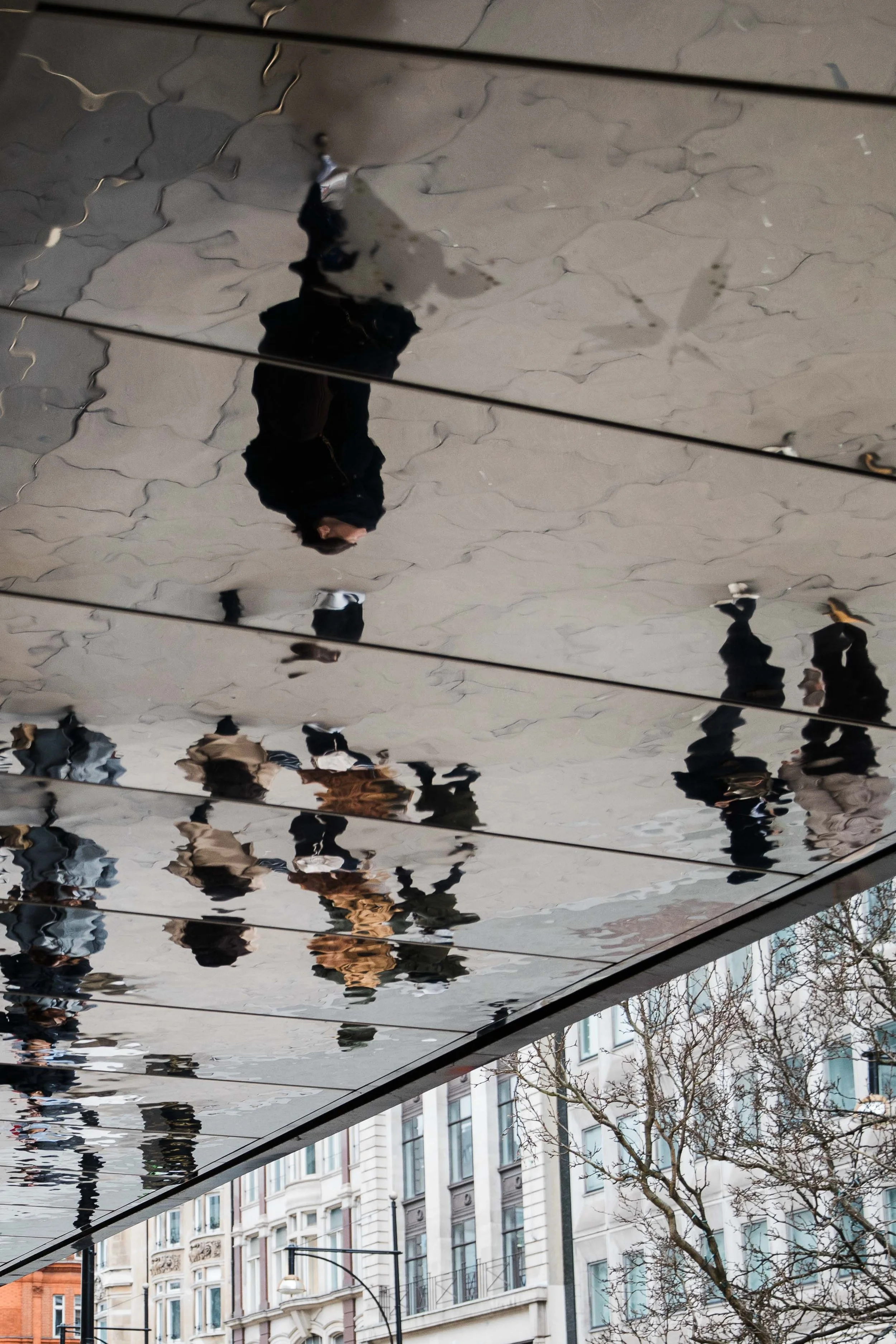 Reflection of people in store overhang, London