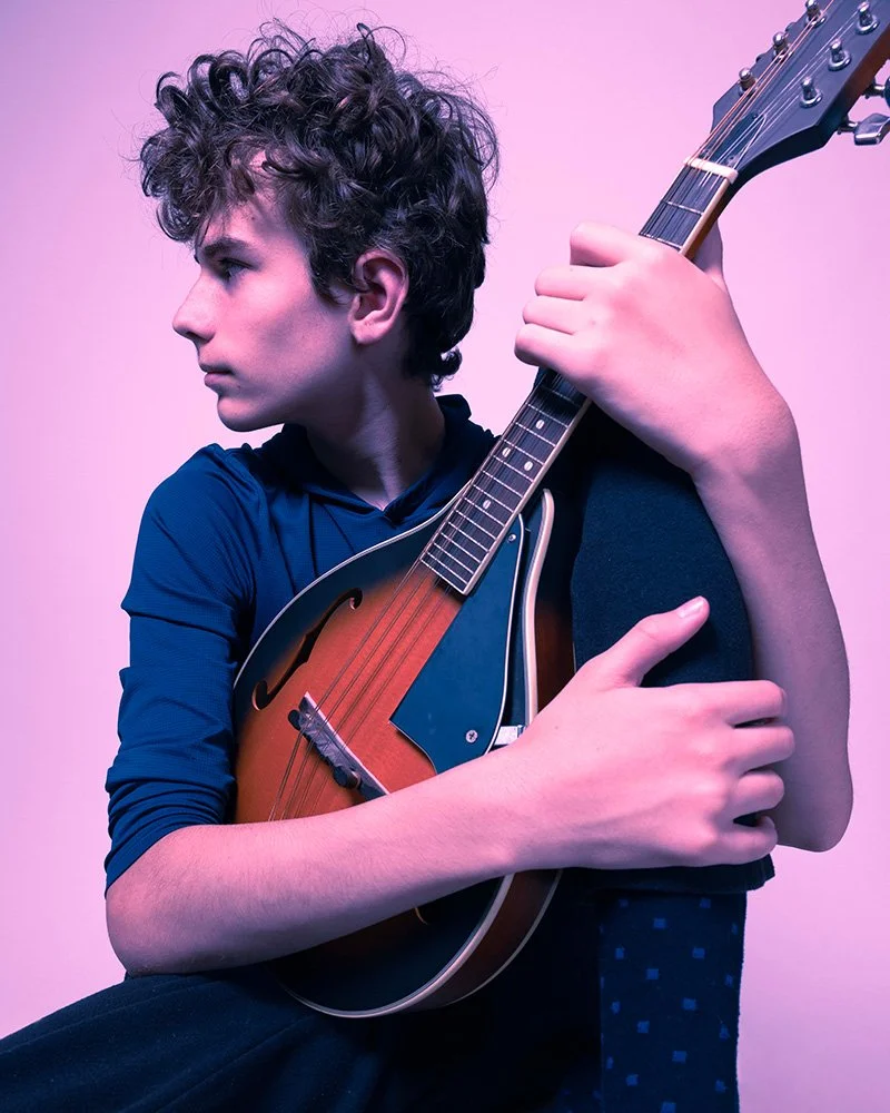 Studio portrait of a yound man with a mandolin