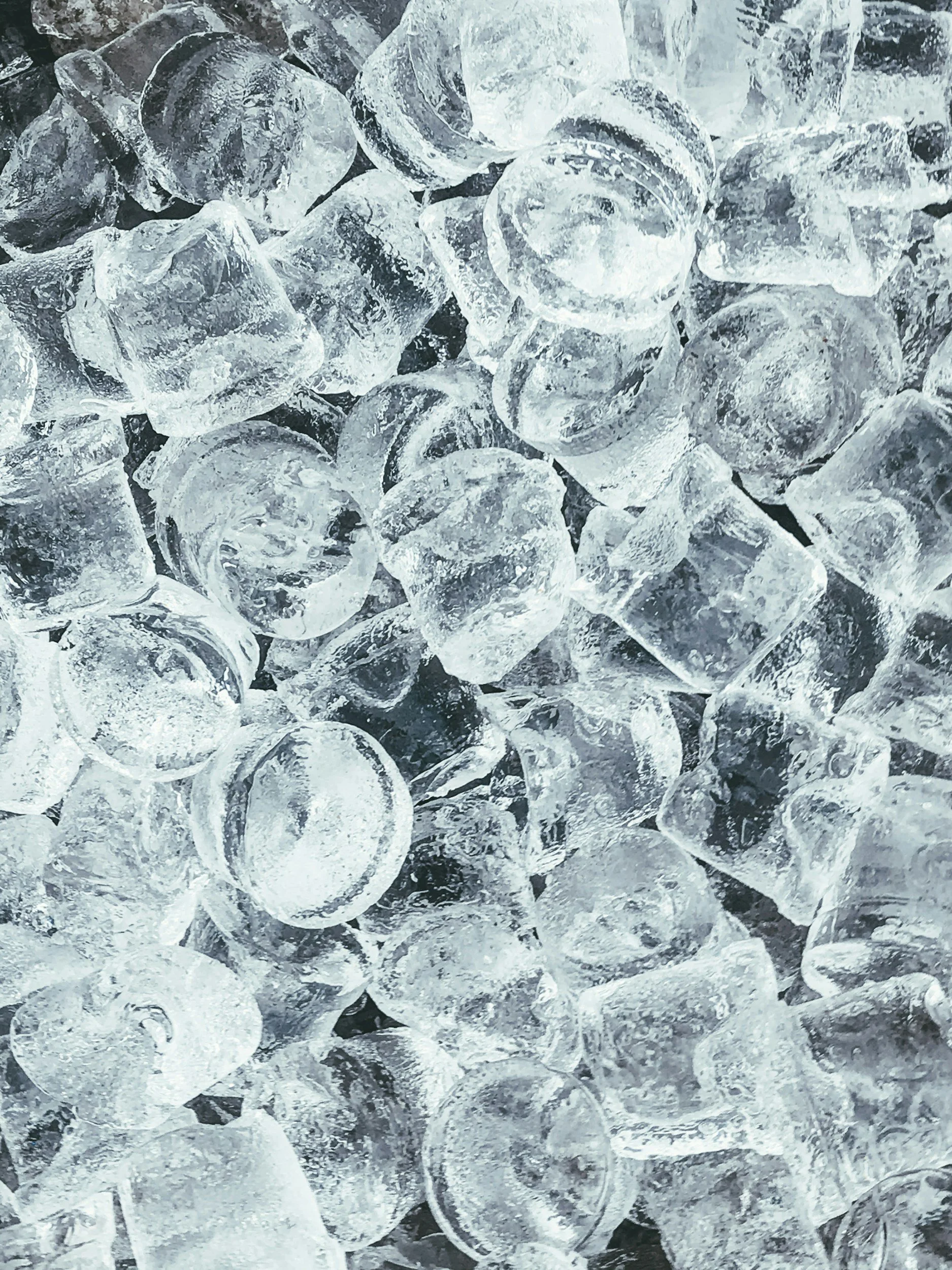 Close-up of ice cubes piled together, showing transparency and texture.