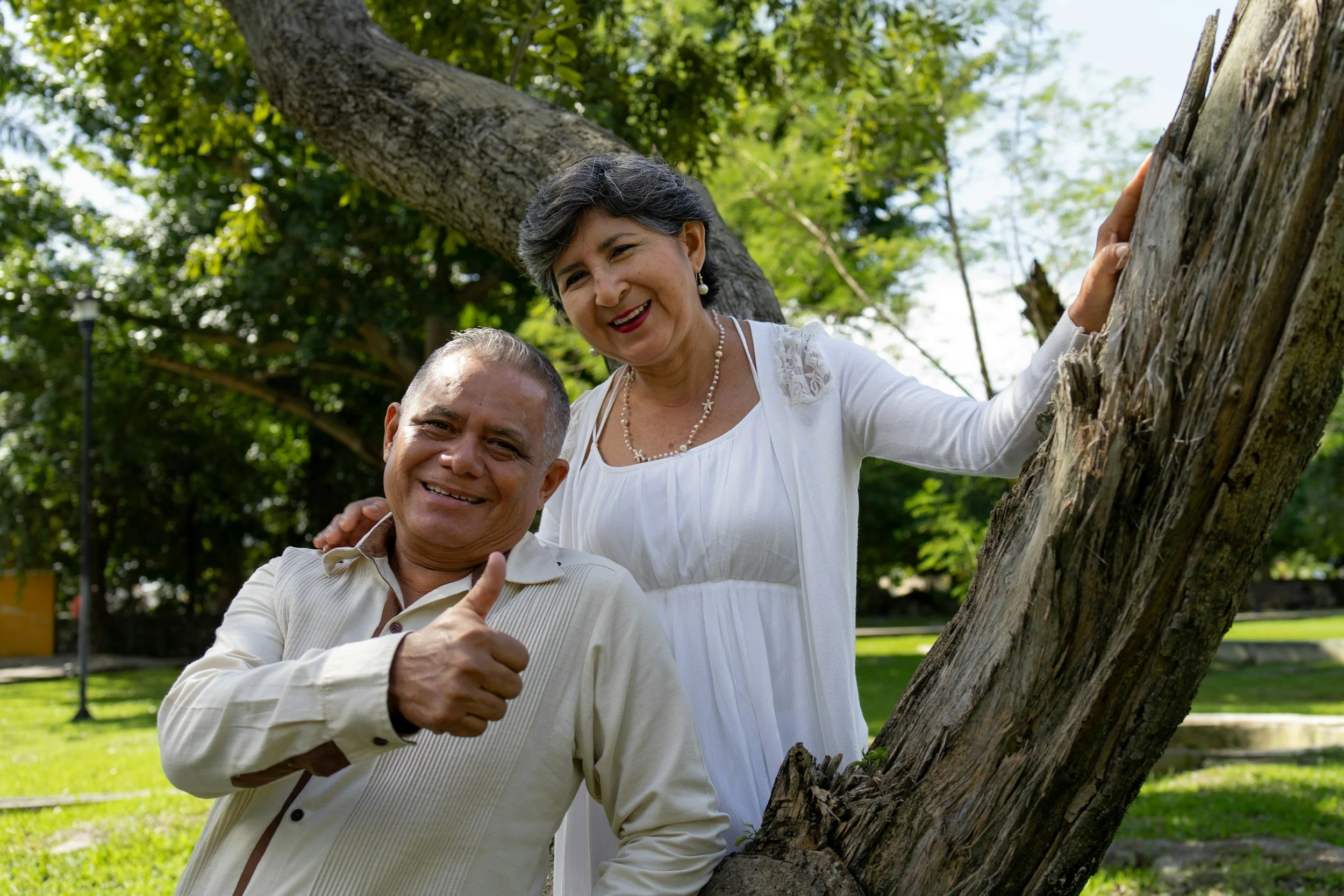 Happy senior couple smiling at the camera while enjoying a peaceful walk in a park in western Colorado.