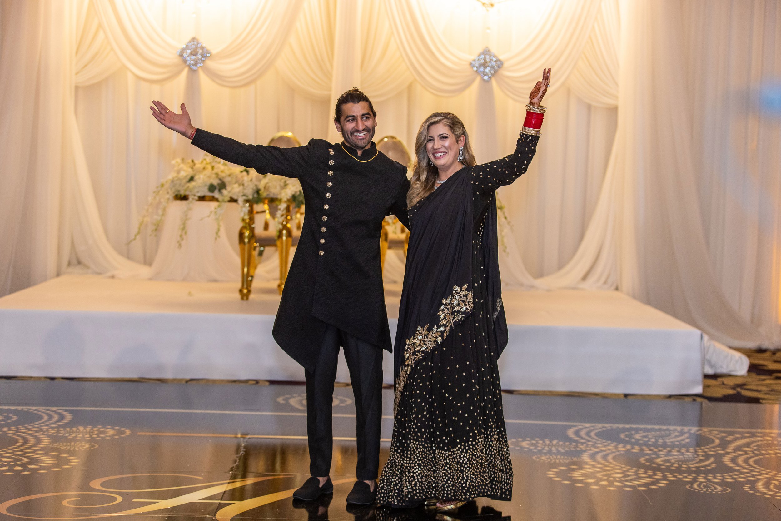 Couple with arms raised on the reception dance floor at the Fairmont Hotel, San Francisco