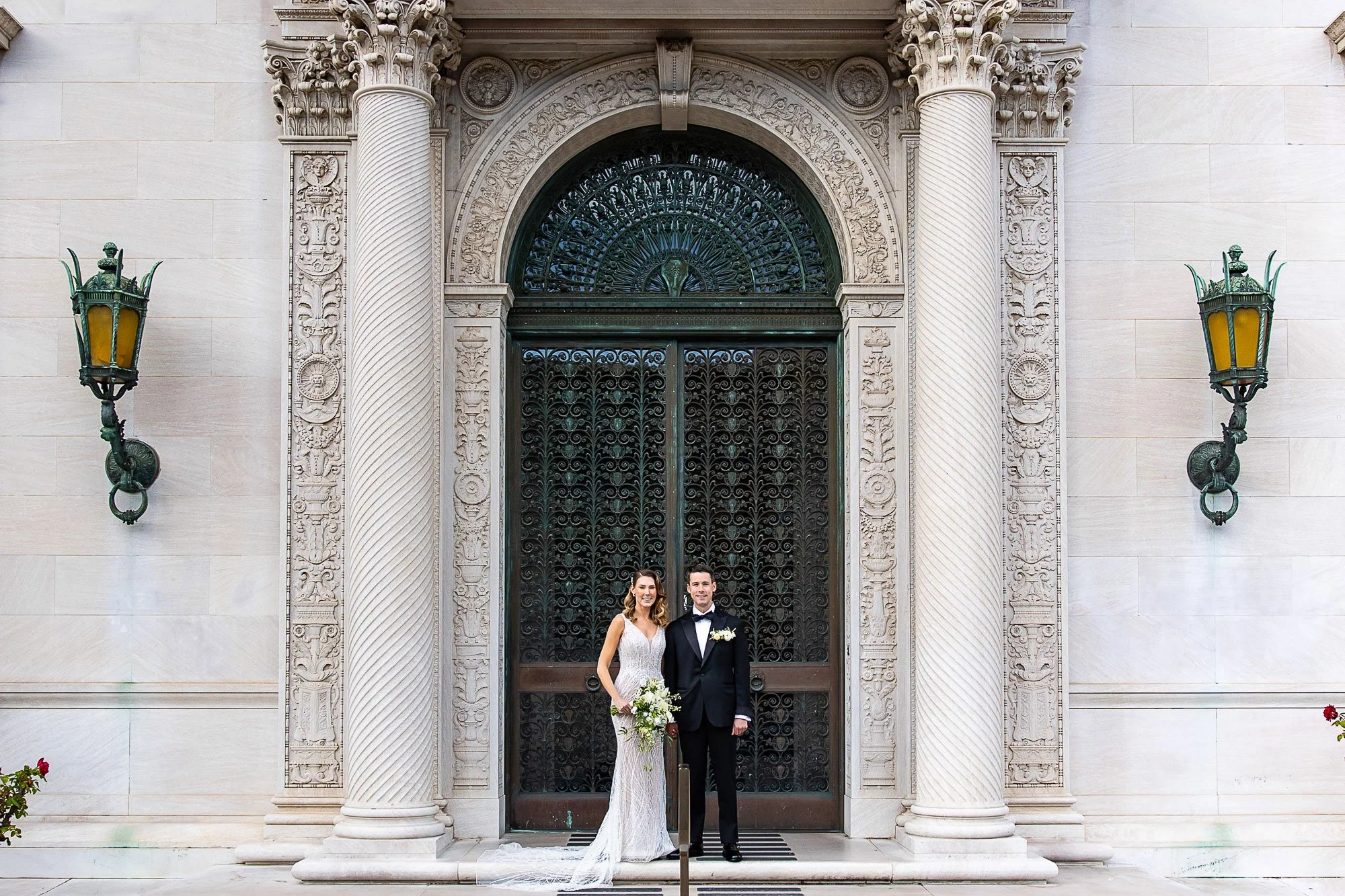Bride and groom in the carved stone doorway of the Flood Mansion, San Francisco
