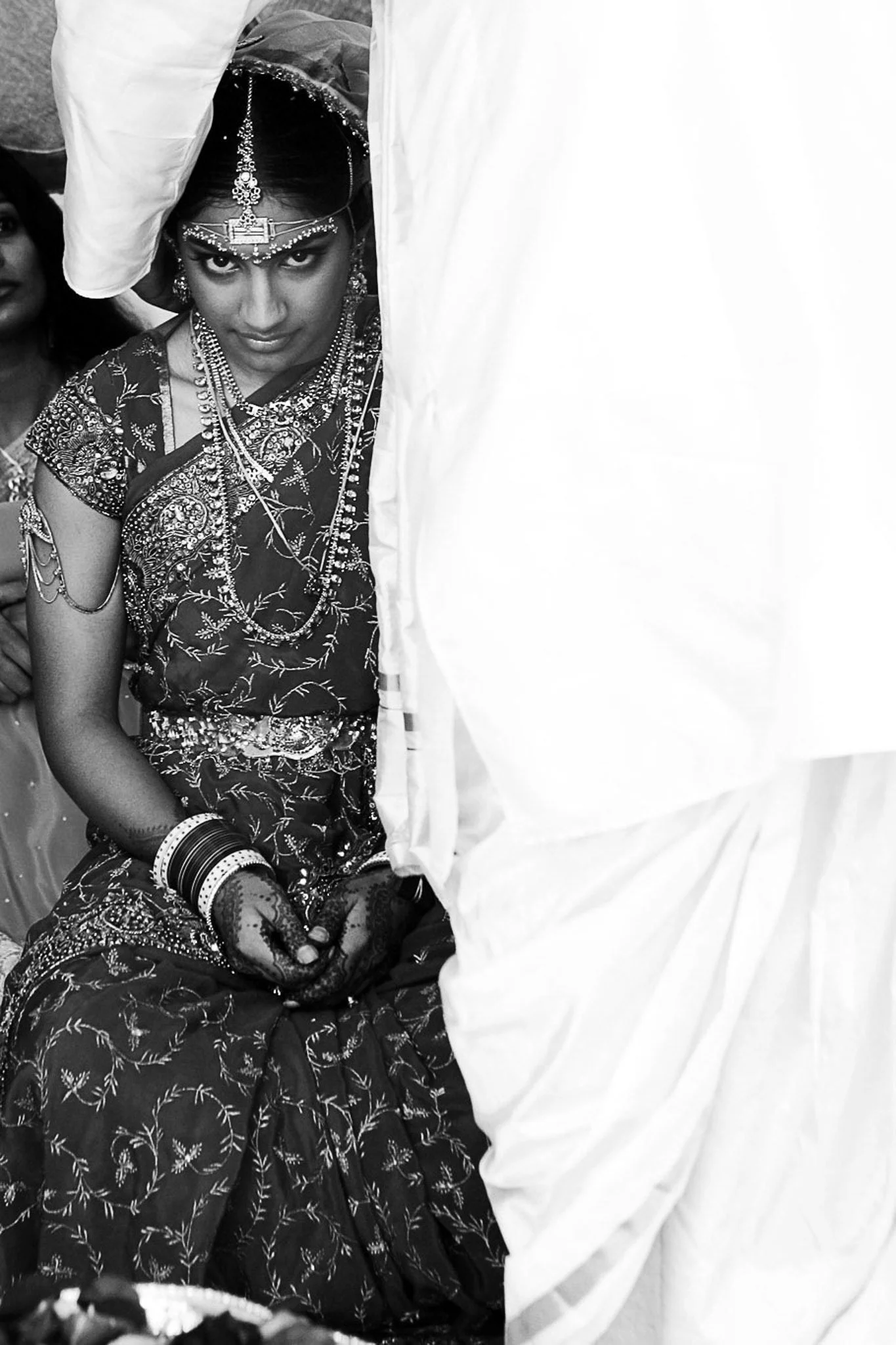 A woman dressed in traditional Indian attire with intricate jewelry, this is the tying of the knot at an Indian wedding at the Villa Montalvo in Saratoga.
