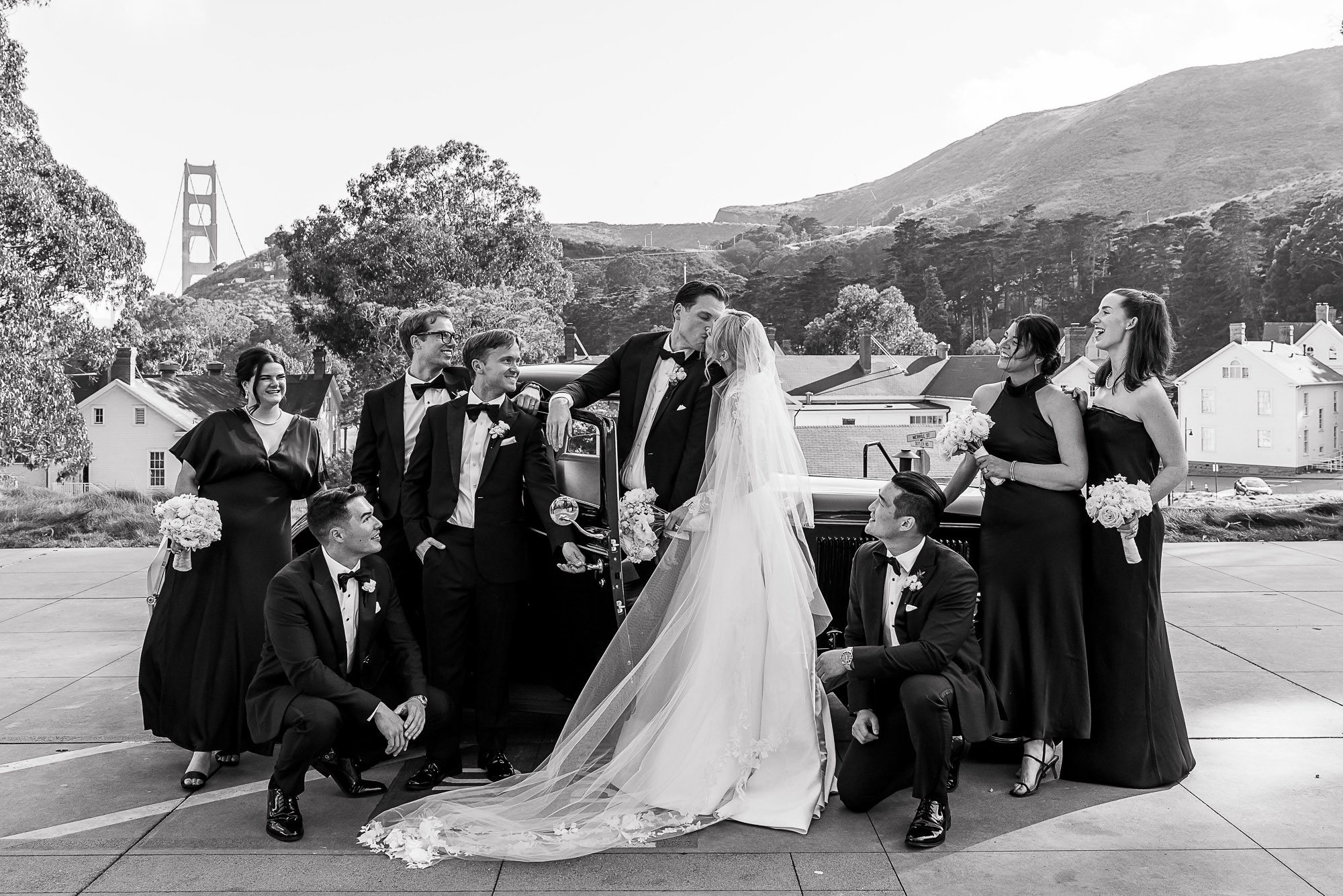 Bridal party kiss beside an antique car at Cavallo Point, Sausalito