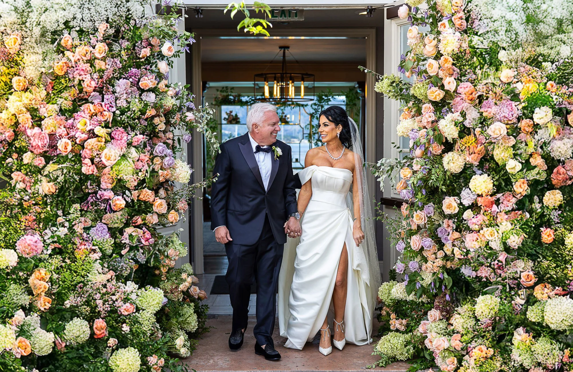 Bride and groom in a flower-covered doorway at Pebble Beach Resorts