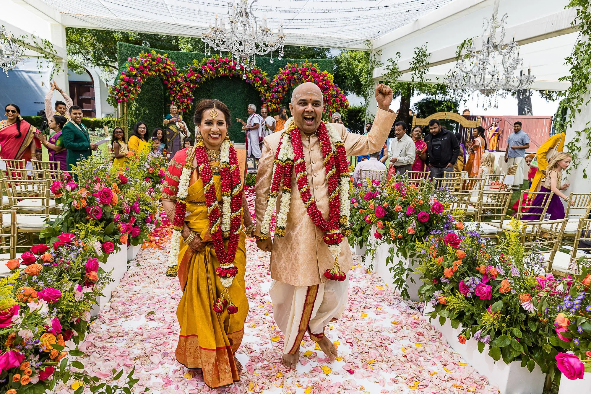 Bride and groom in traditional dress celebrating as they exit their Indian wedding ceremony at Wente Vineyards, Livermore Valley