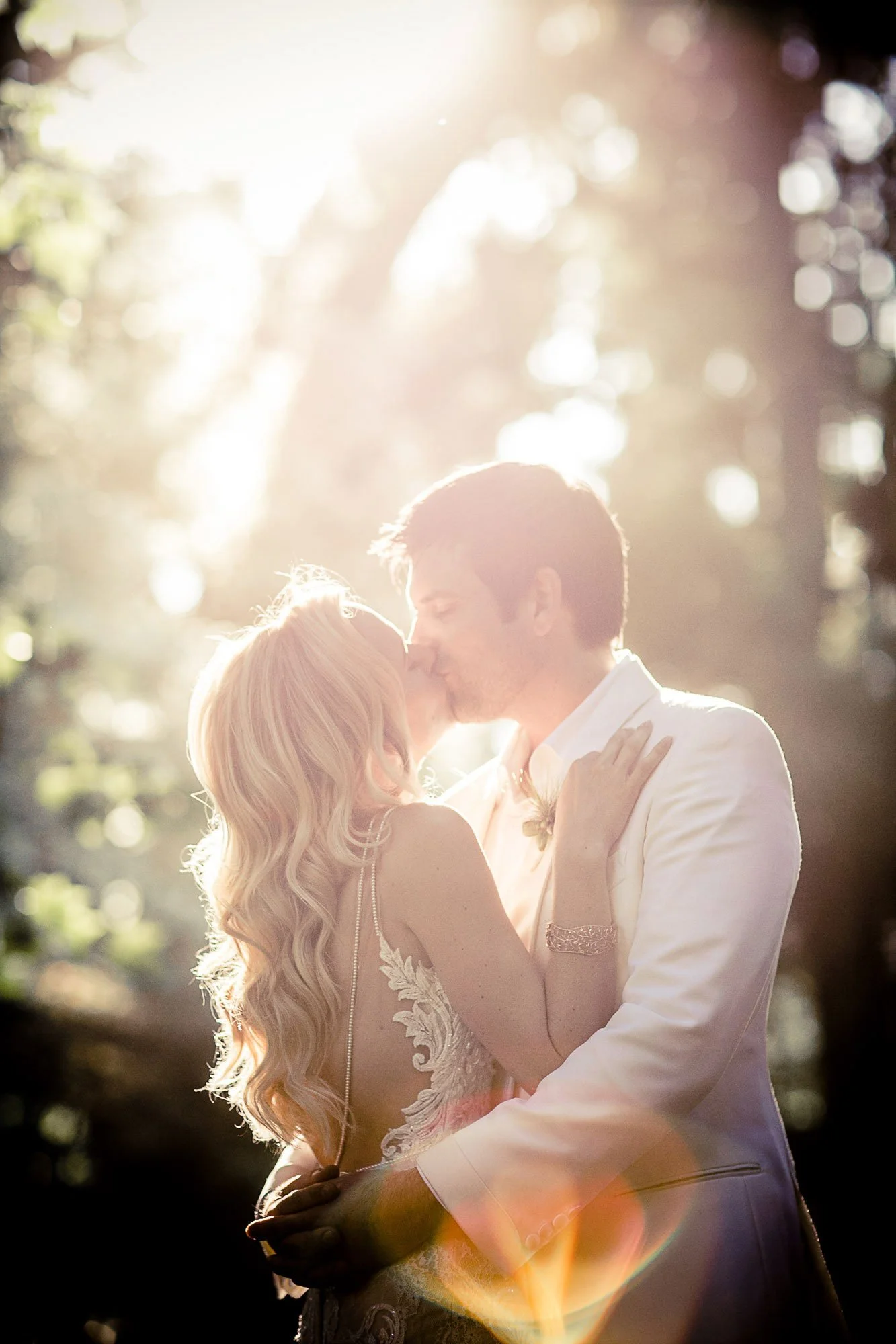 Bride and groom kissing in backlit sunlight at Beaulieu Garden, Napa Valley