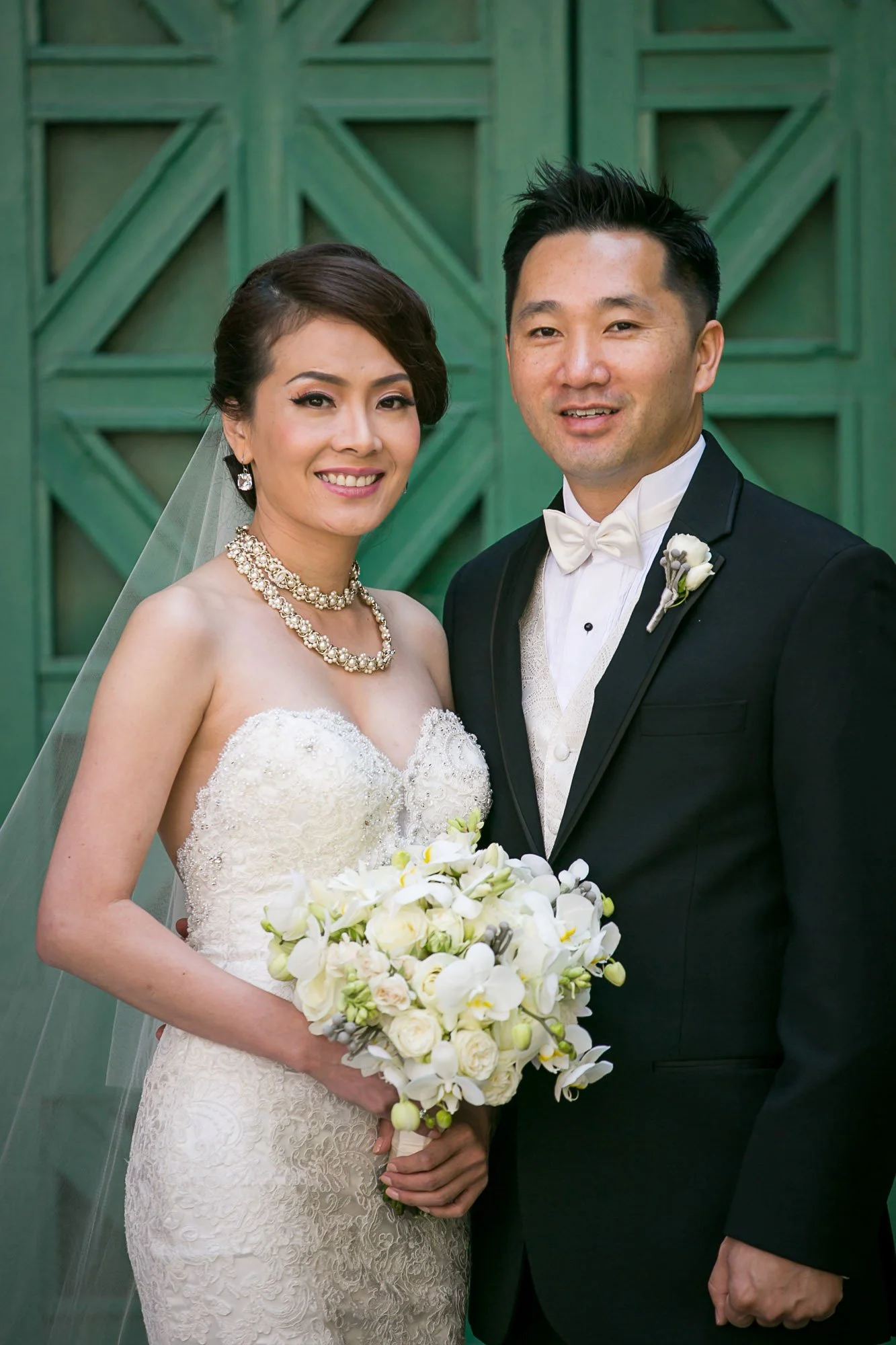 Bride and groom in front of the green lacquered doors at the Fairmont Hotel, San Francisco
