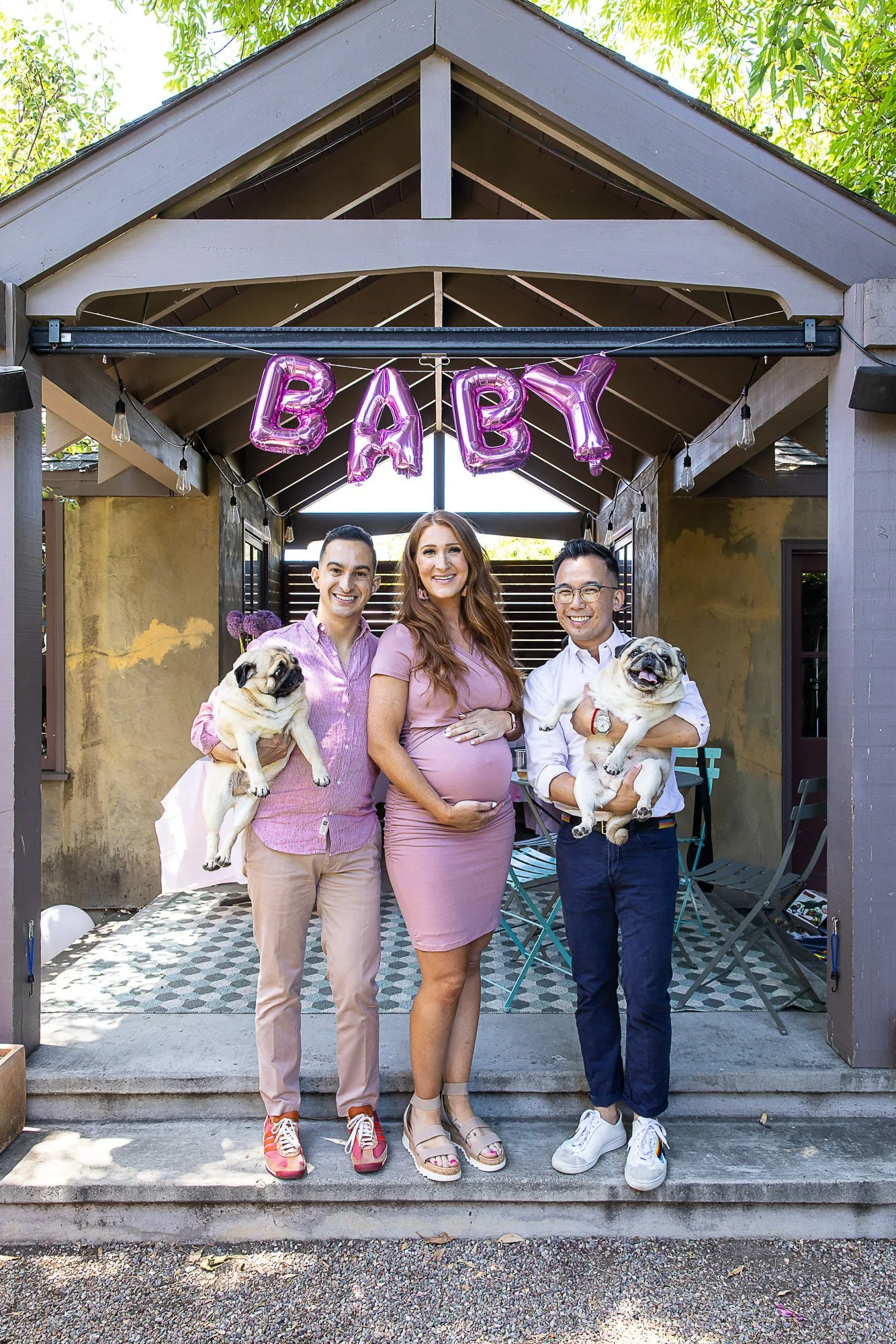 Expectant parents with friends and their pugs at a baby shower