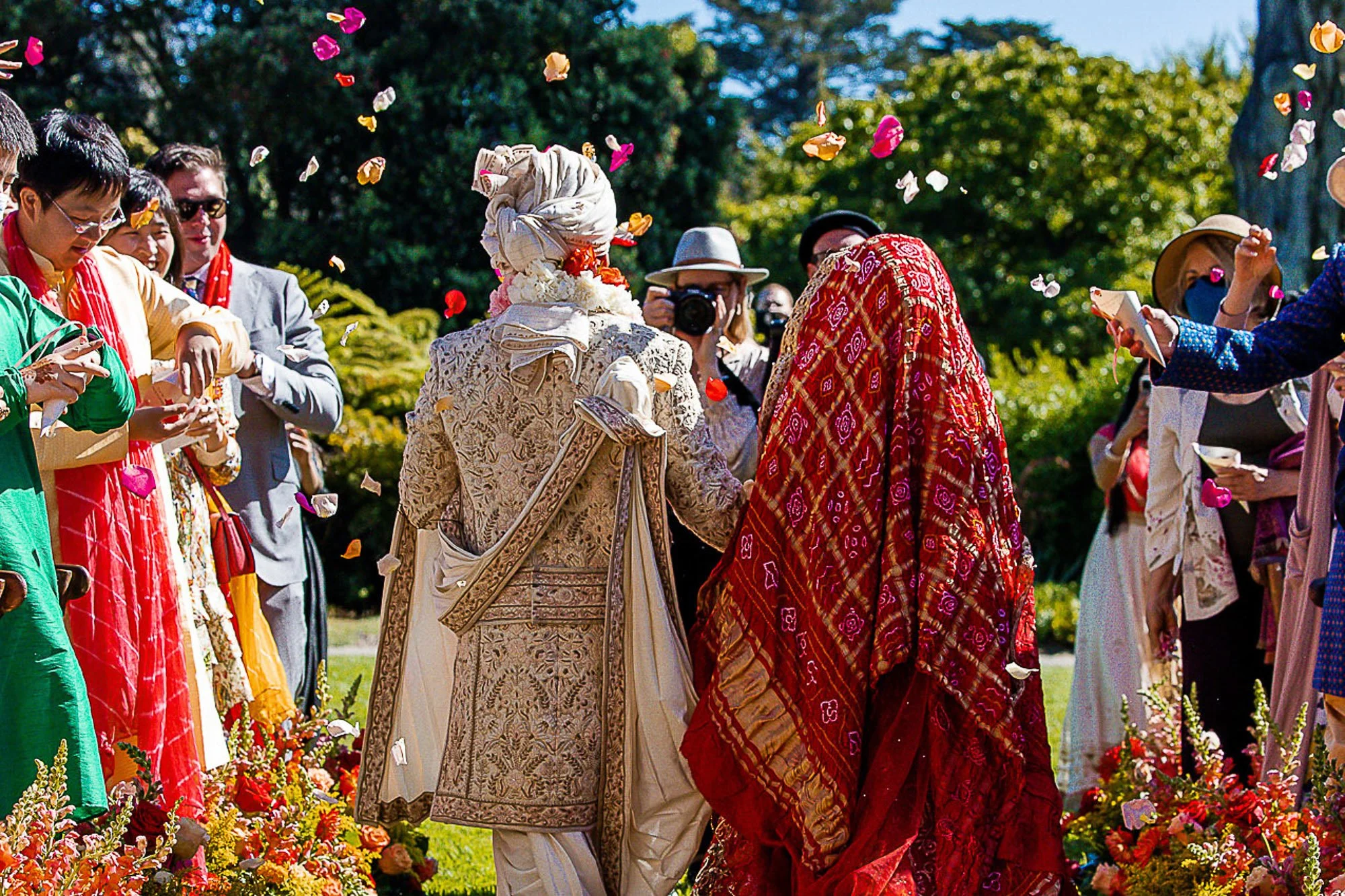 Guests throwing flower petals over the couple as they leave the ceremony