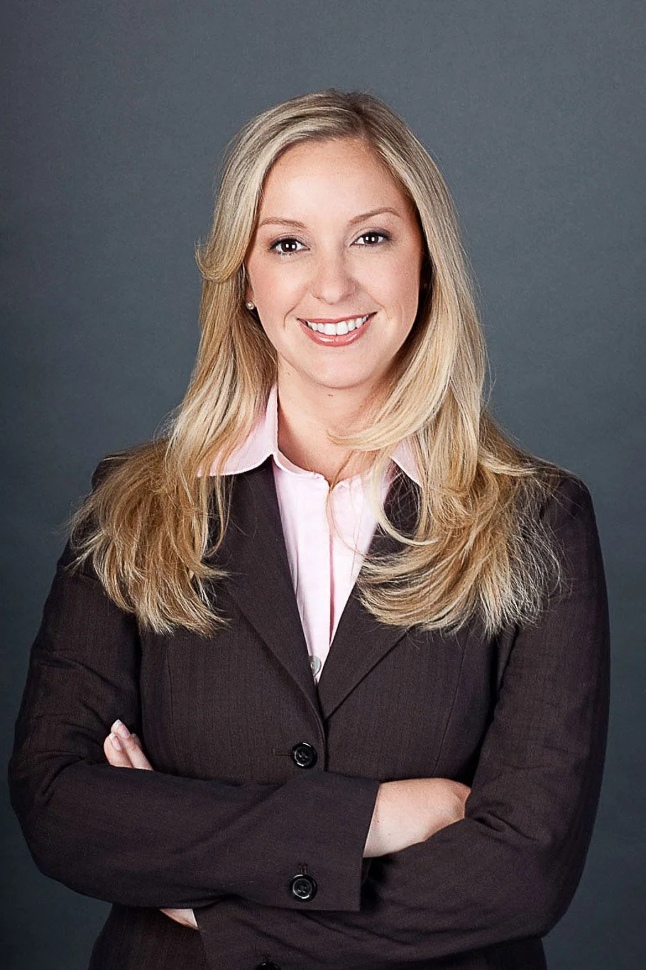 Executive headshot of a woman against a neutral studio background