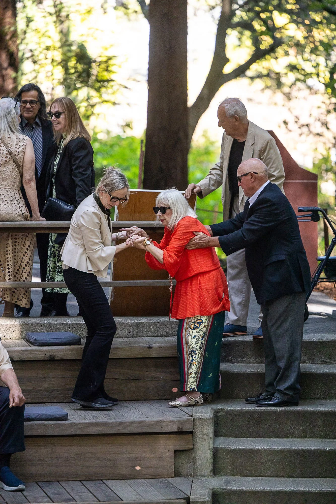 Tara Arrowood with at a wedding ceremony helping a disabled person find her seat.