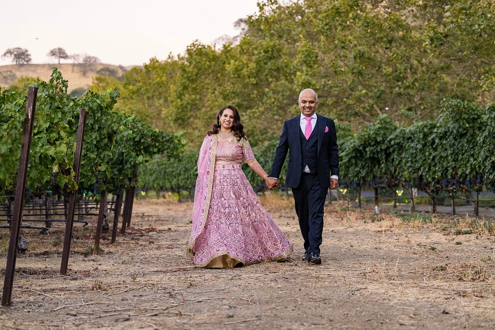 Bride and groom walking the vineyard at Wente Vineyards, Livermore