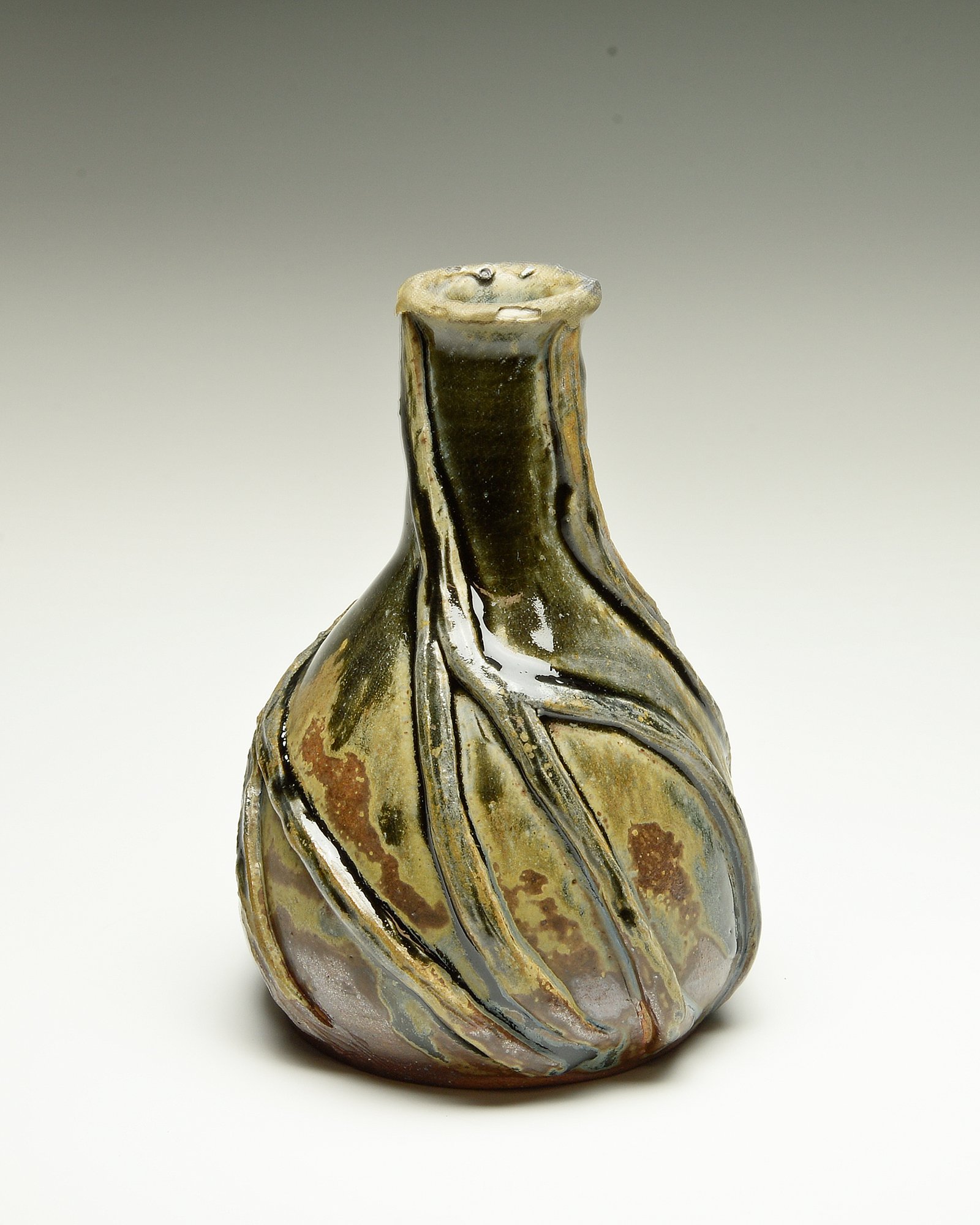 Close-up of a decorative glass vase with swirling marble-like pattern in earth tones, against a plain light background.