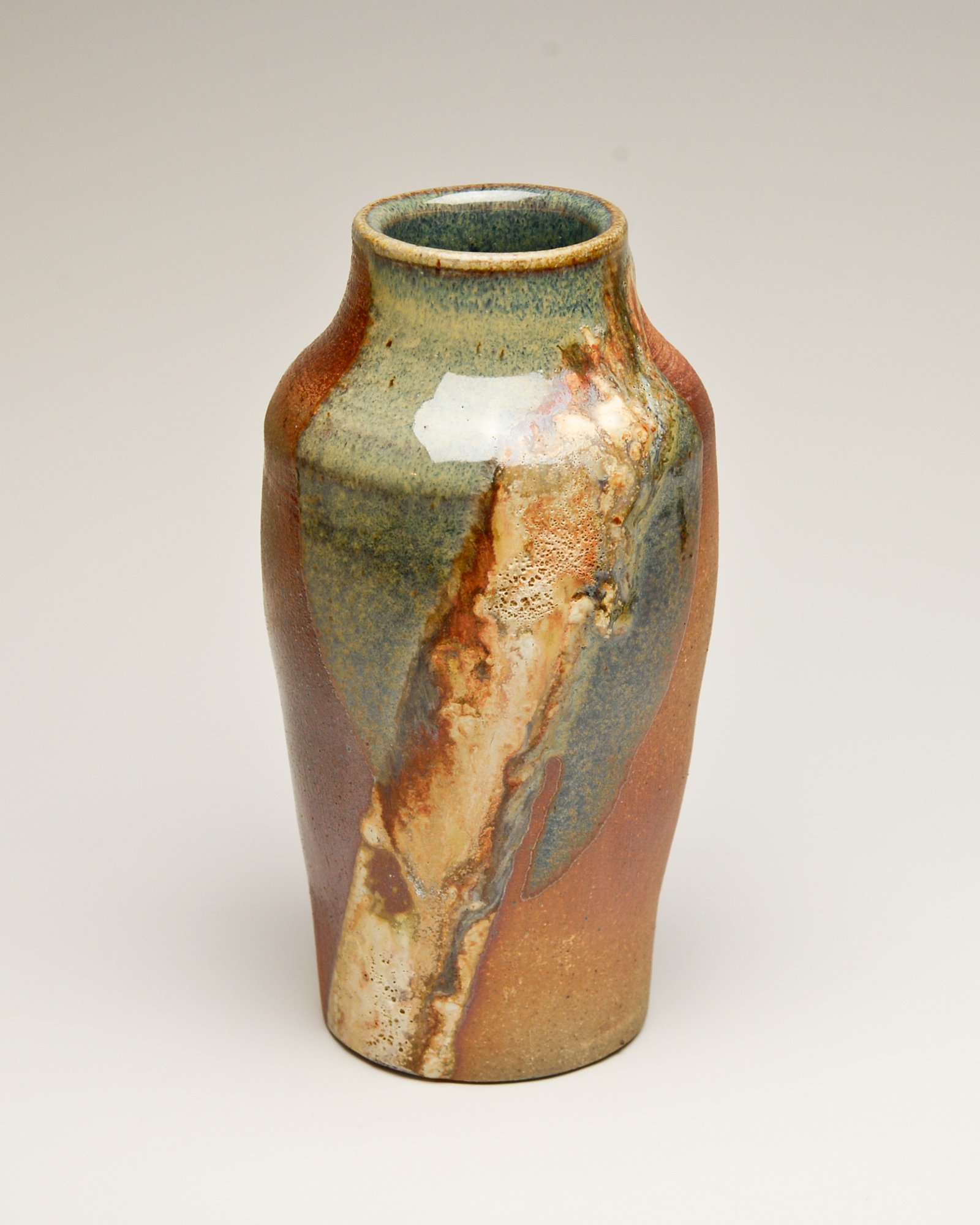 A ceramic vase with a mix of earthy colors and textured patterns