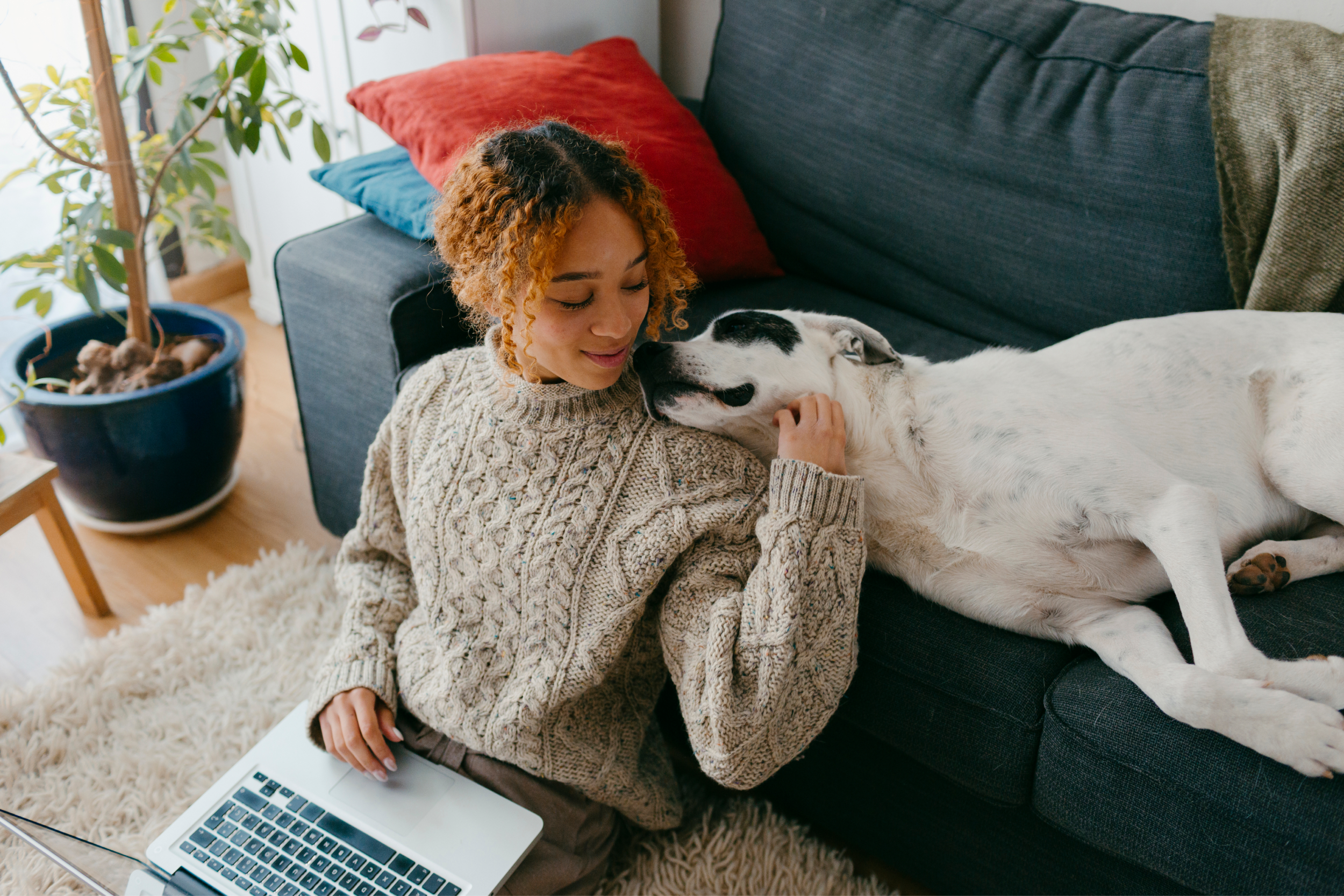 Woman Cuddling with Dog on Couch