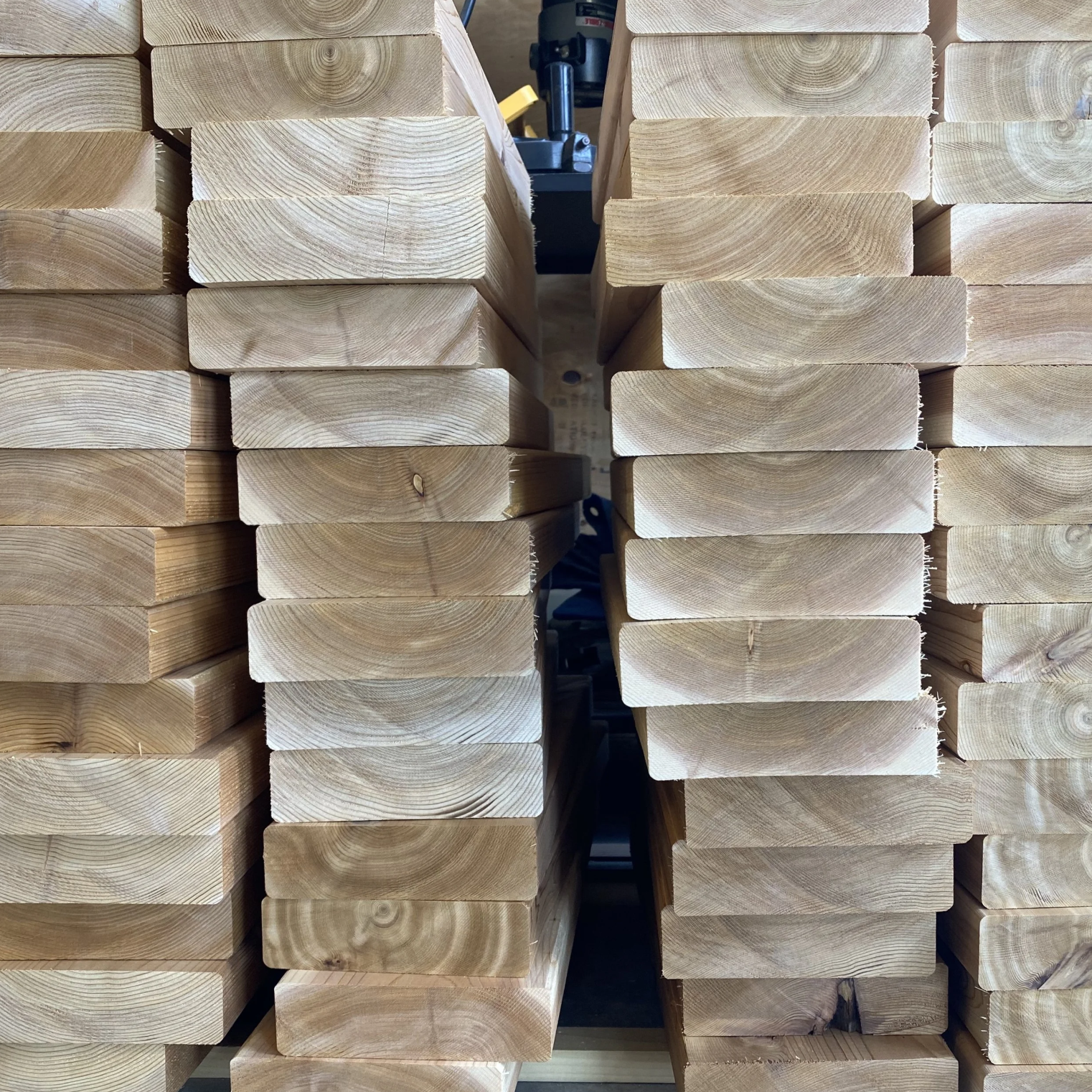 Stacks of cut wooden boards arranged in rows in a woodworking shop.
