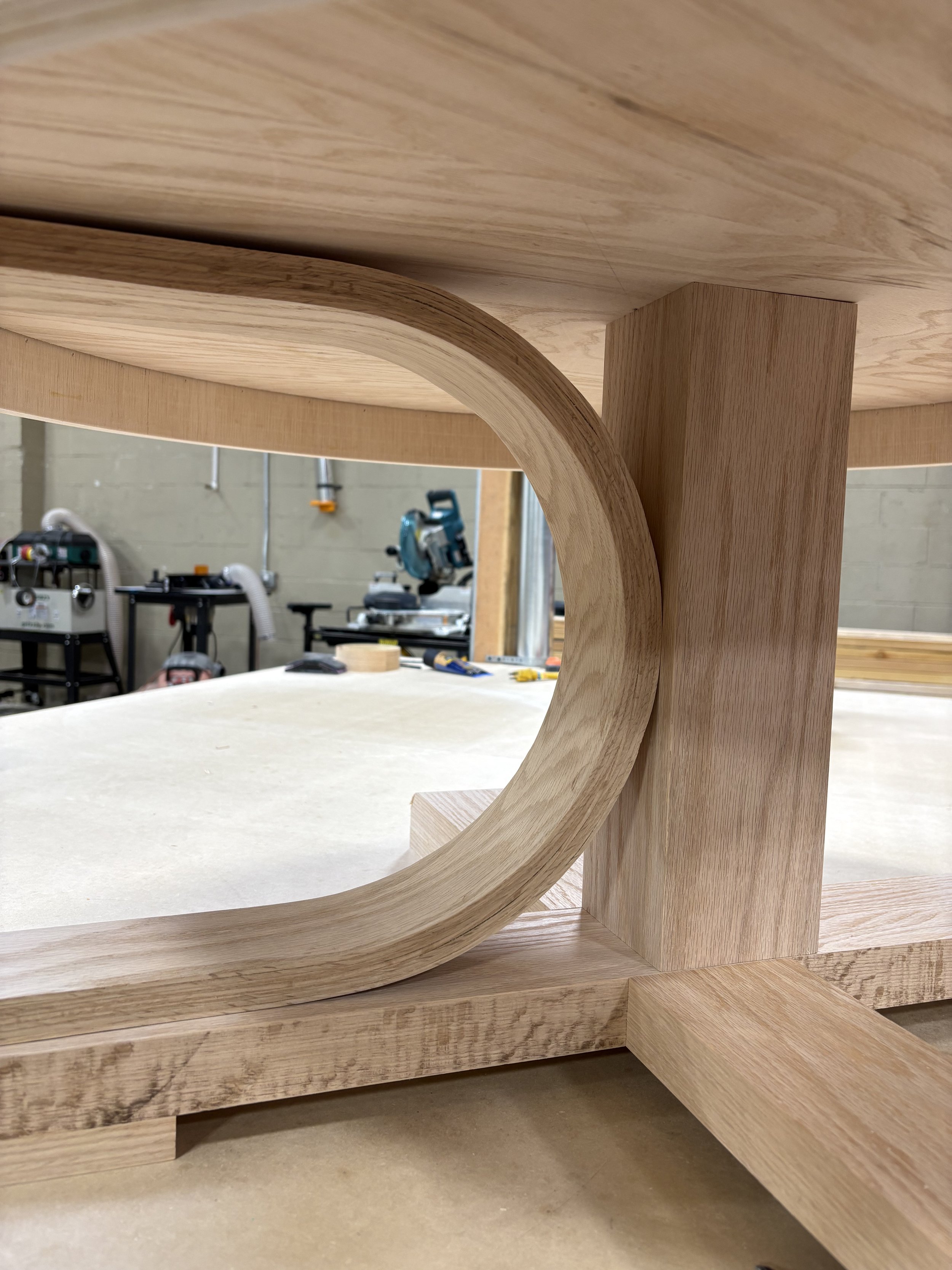 Close-up of a wooden structure with curved and straight components in a woodworking or carpentry workshop.