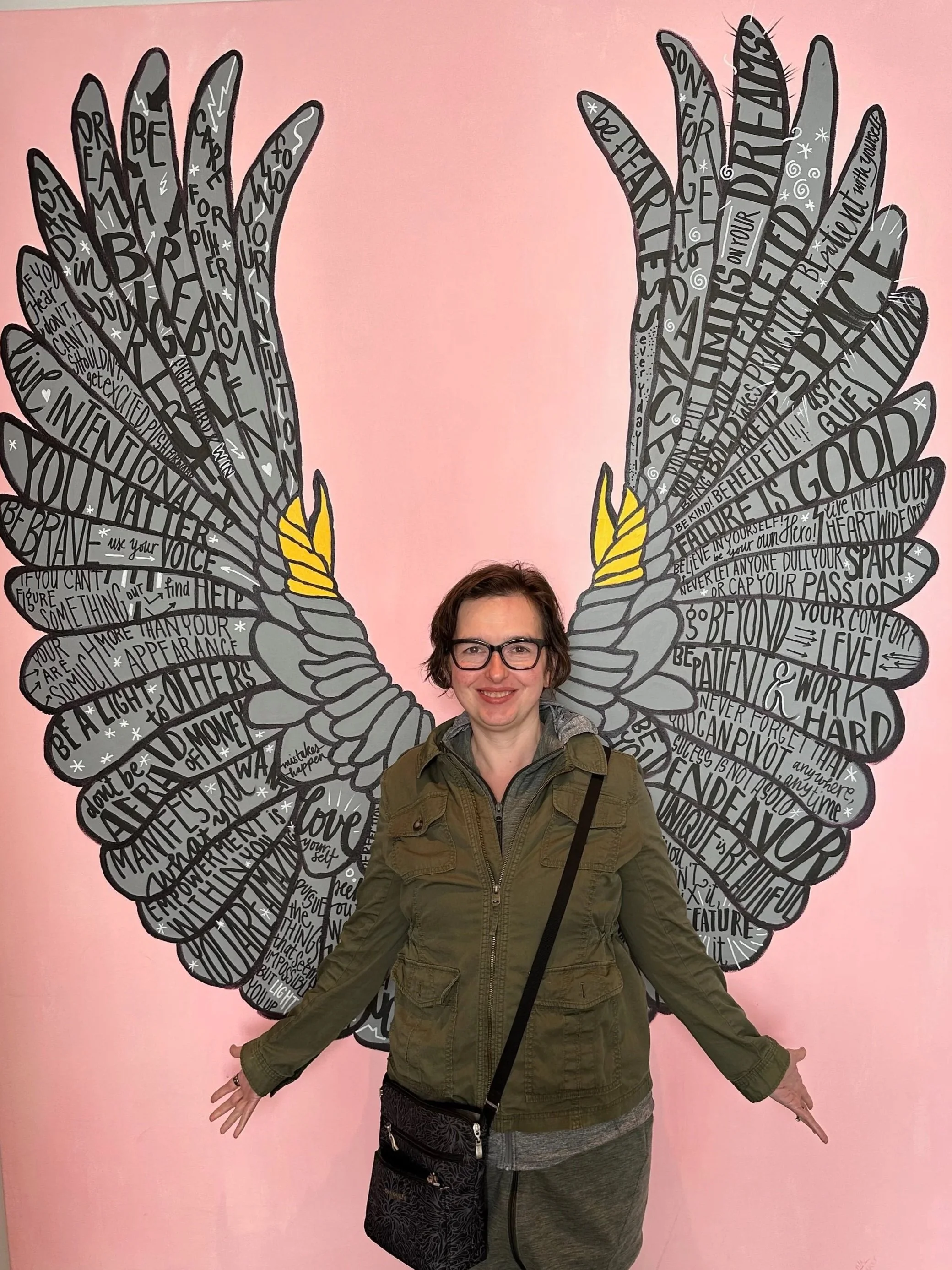 Kitty Ireland standing in front of illustrated angel wings