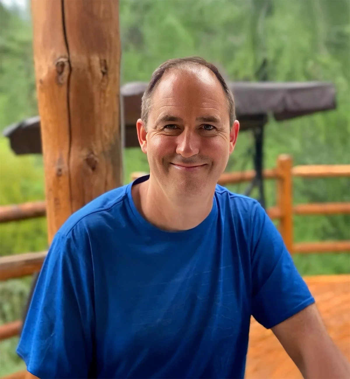 Chris Knuth headshot portrait with a wooded, green background