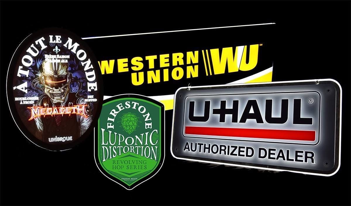 Collection of four stickers or decals, including a Megadeth band logo, a Fierstone Luponic Distortion sticker, a Western Union logo, and a U-Haul authorized dealer sign, all on a black background.