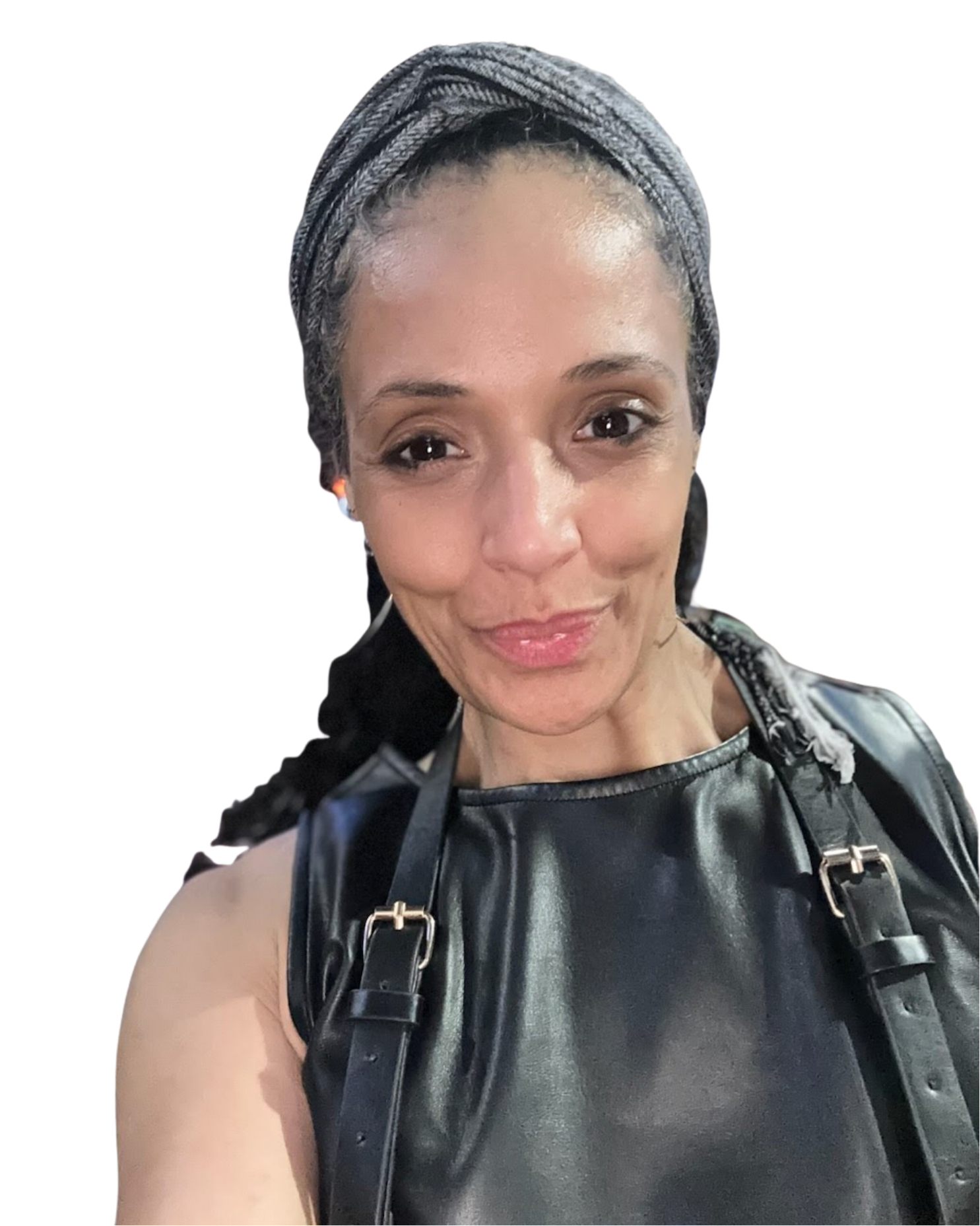 Close-up of a smiling woman with braided hair, wearing a black leather top and a black backpack, possibly outdoors or at an event.